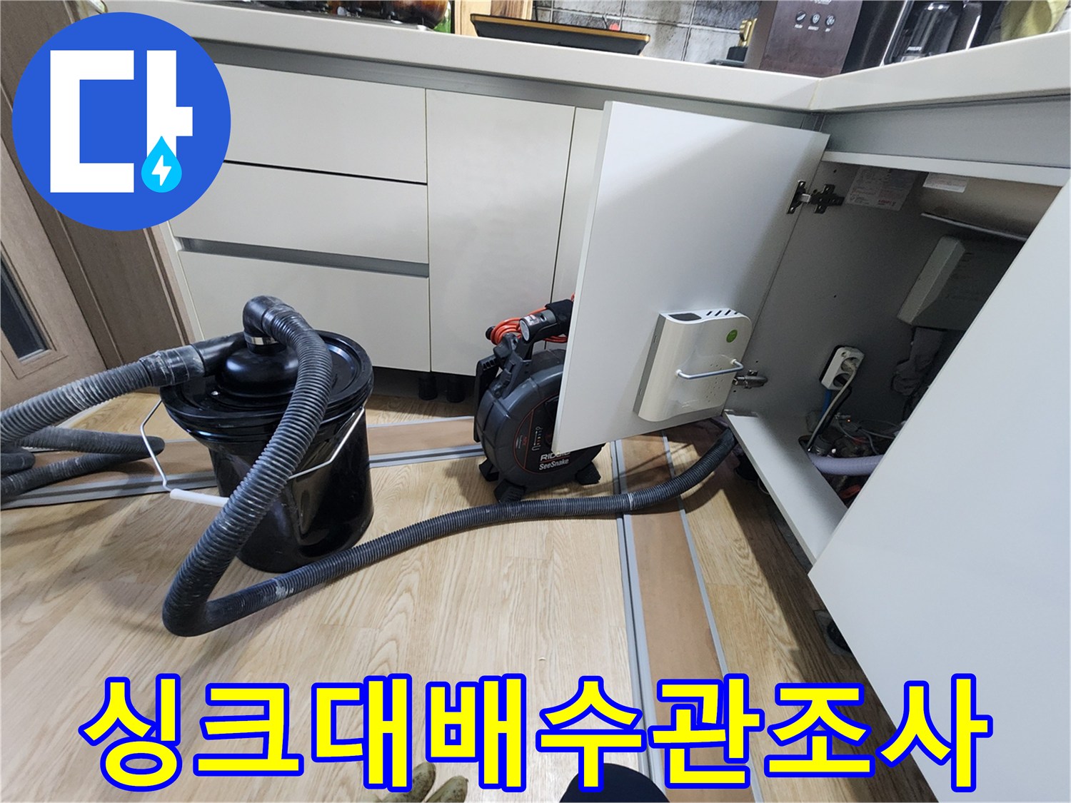 싱크대 하부장 내부의 배관 구조와 연결 상태 점검 중