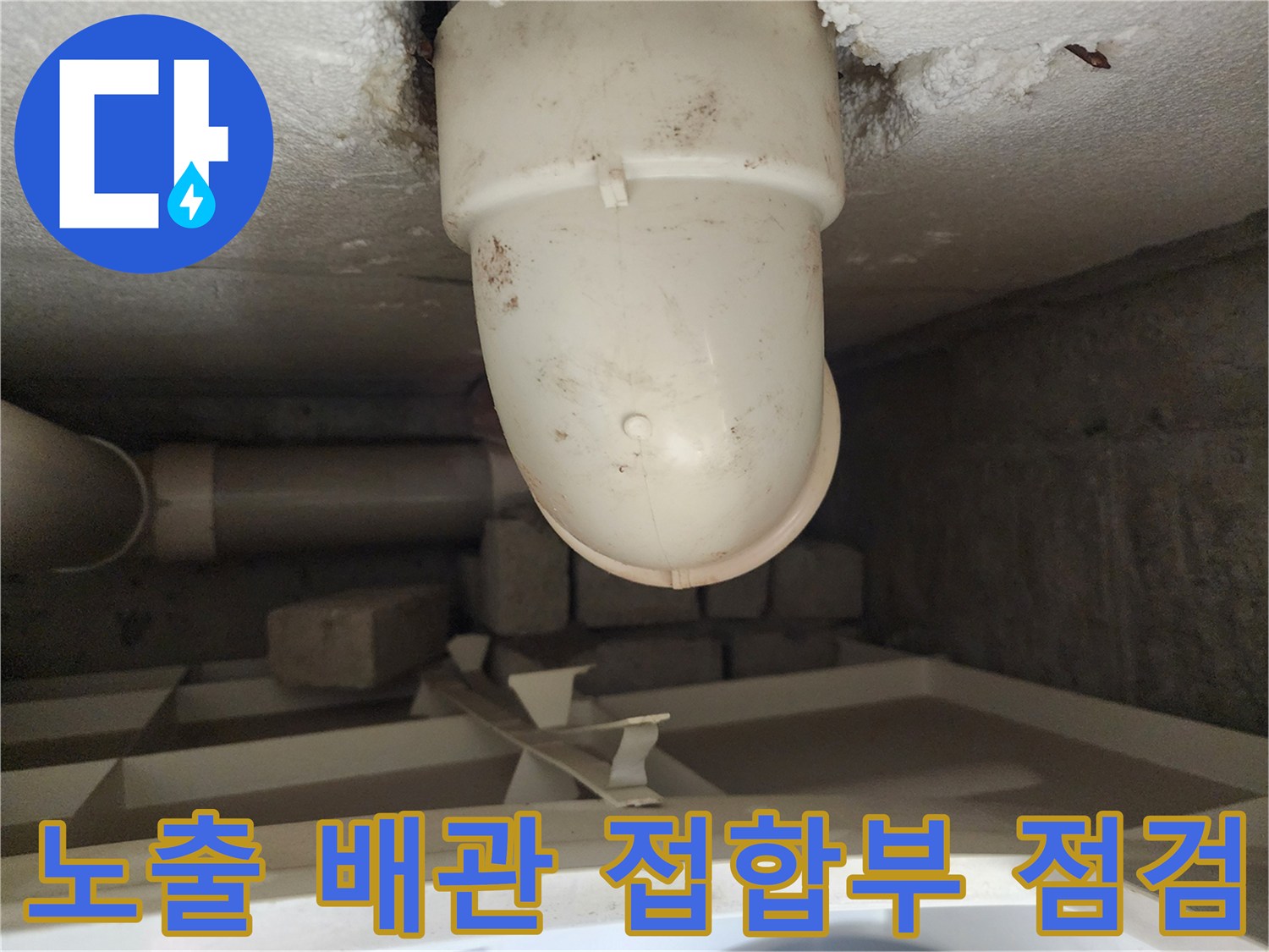 흰색 PVC 배관의 굴곡진 연결 부위와 주변 마감 상태