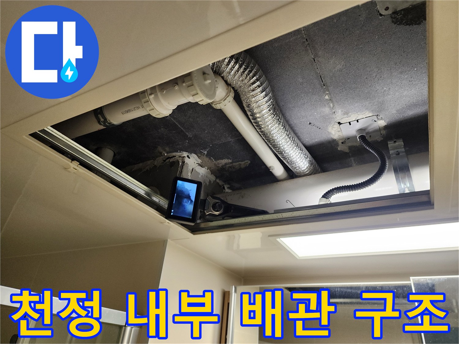 욕실 천정 내부의 은색 주름관과 하얀색 PVC 배부 연결 부위