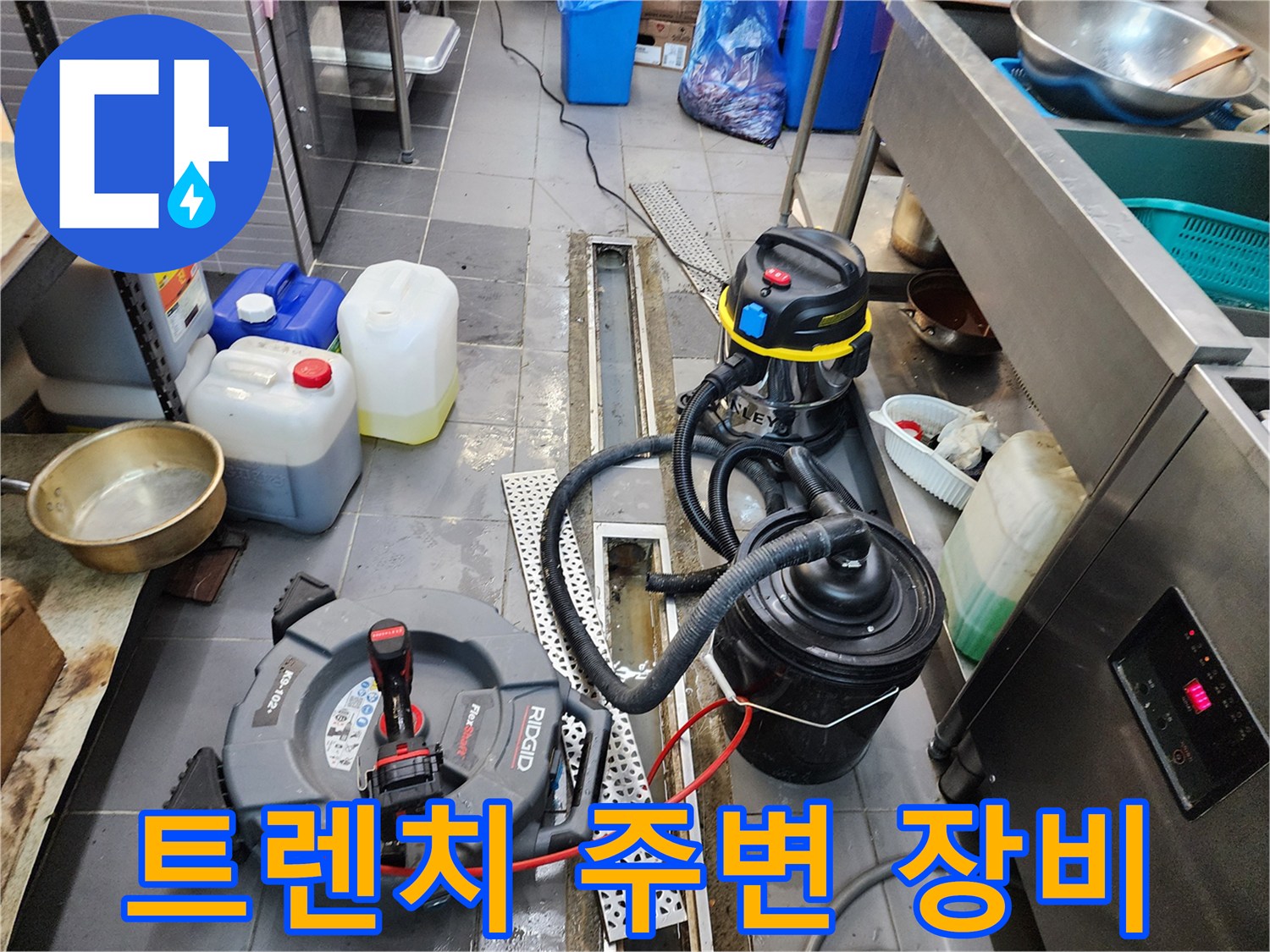 식당 주방 바닥 - 배수 트렌치와 작업용 장비들이 놓여 있습니다.
