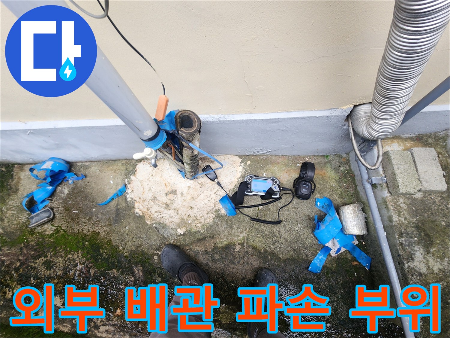 건물 외벽에 연결된 외부 배관의 파손 및 노후 상태를 보여주는 사진입니다.