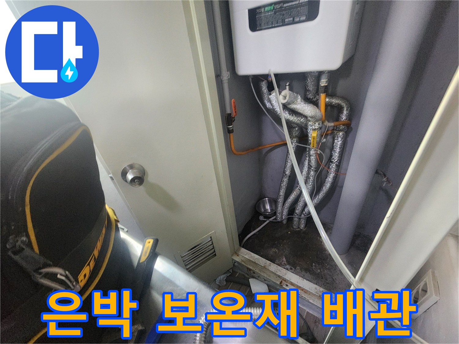 은색 보온재가 씌워진 배관과 하단에 위치한 흰색 보일러 장비