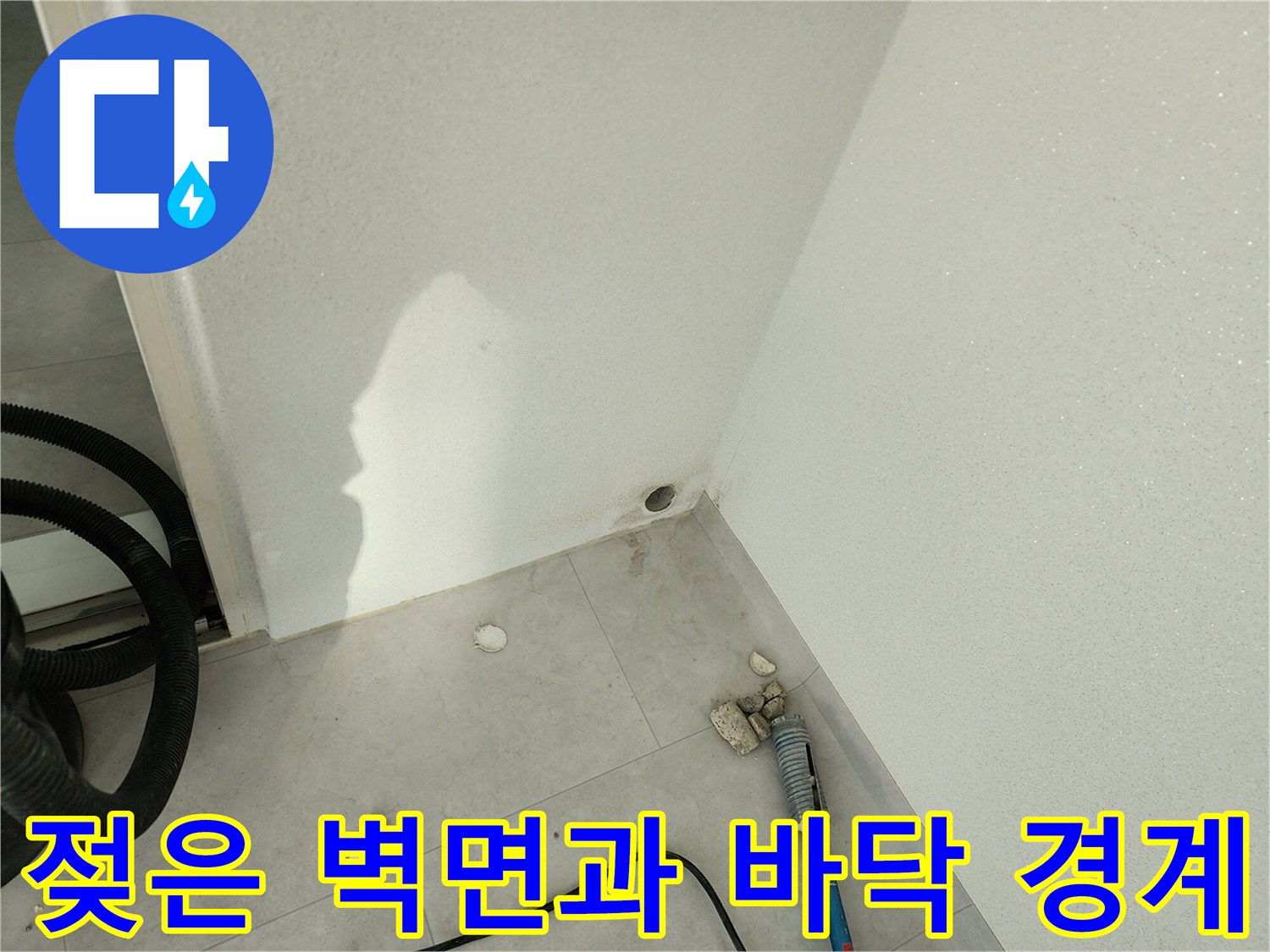 습기가 스며든 베란다 벽체 하단과 타일 사이의 모습