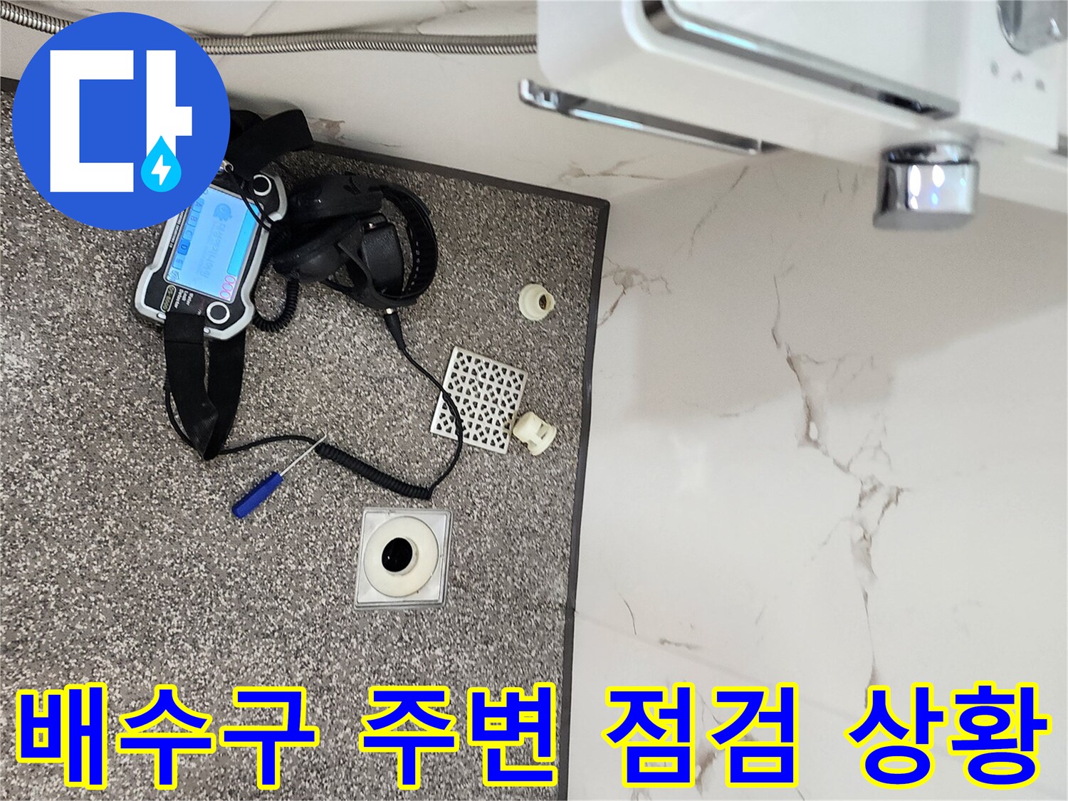 욕실 바닥 배수구와 탐지 장비가 놓여 있는 현장 모습