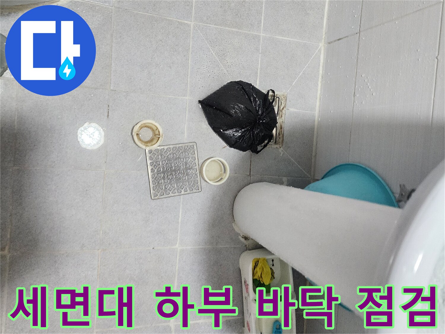세면대 아래쪽 욕실 배수구와 타일 바닥 사진입니다.