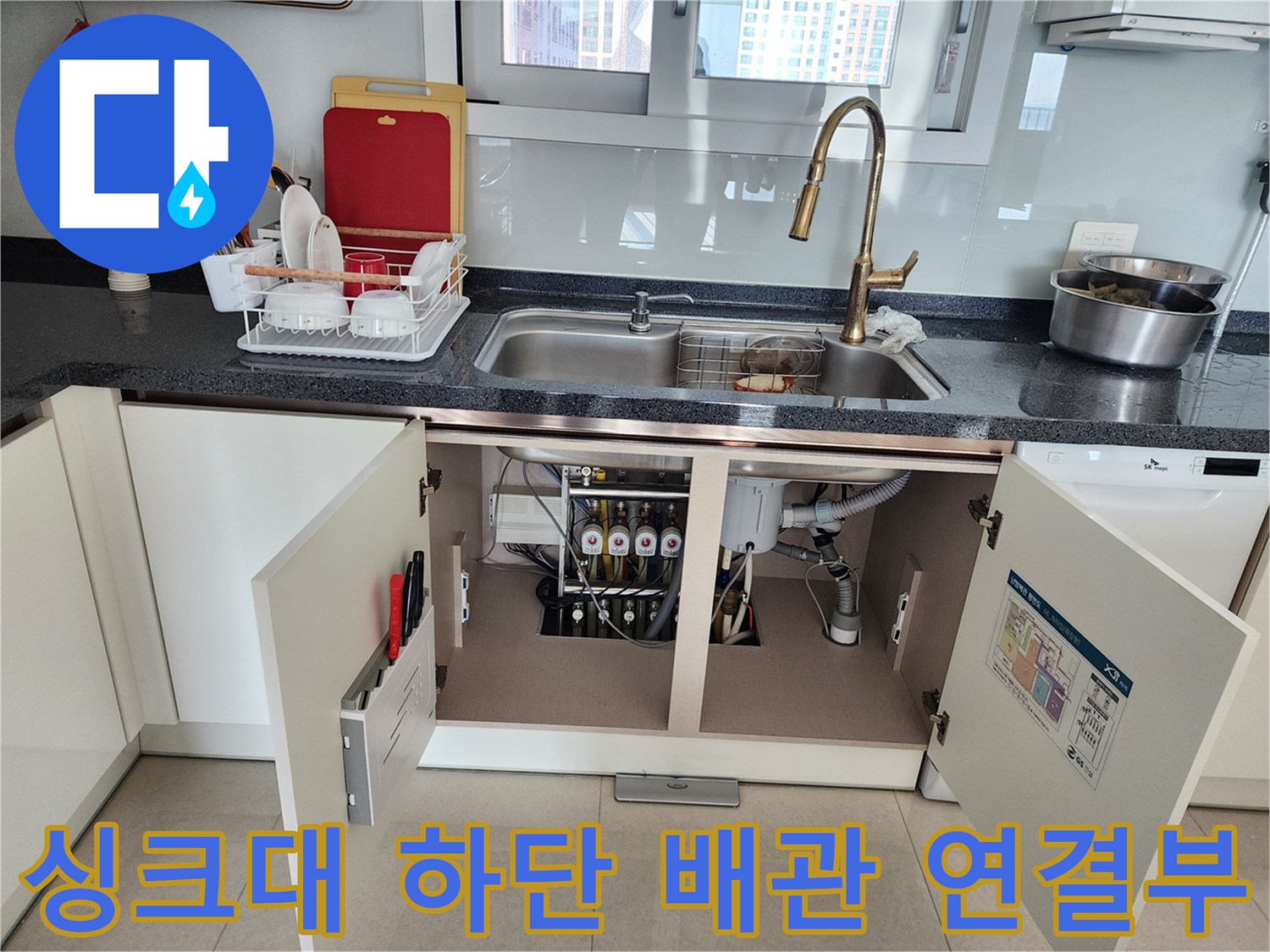 열린 하부장 내부의 싱크대 배수관 및 유가 부위 모습