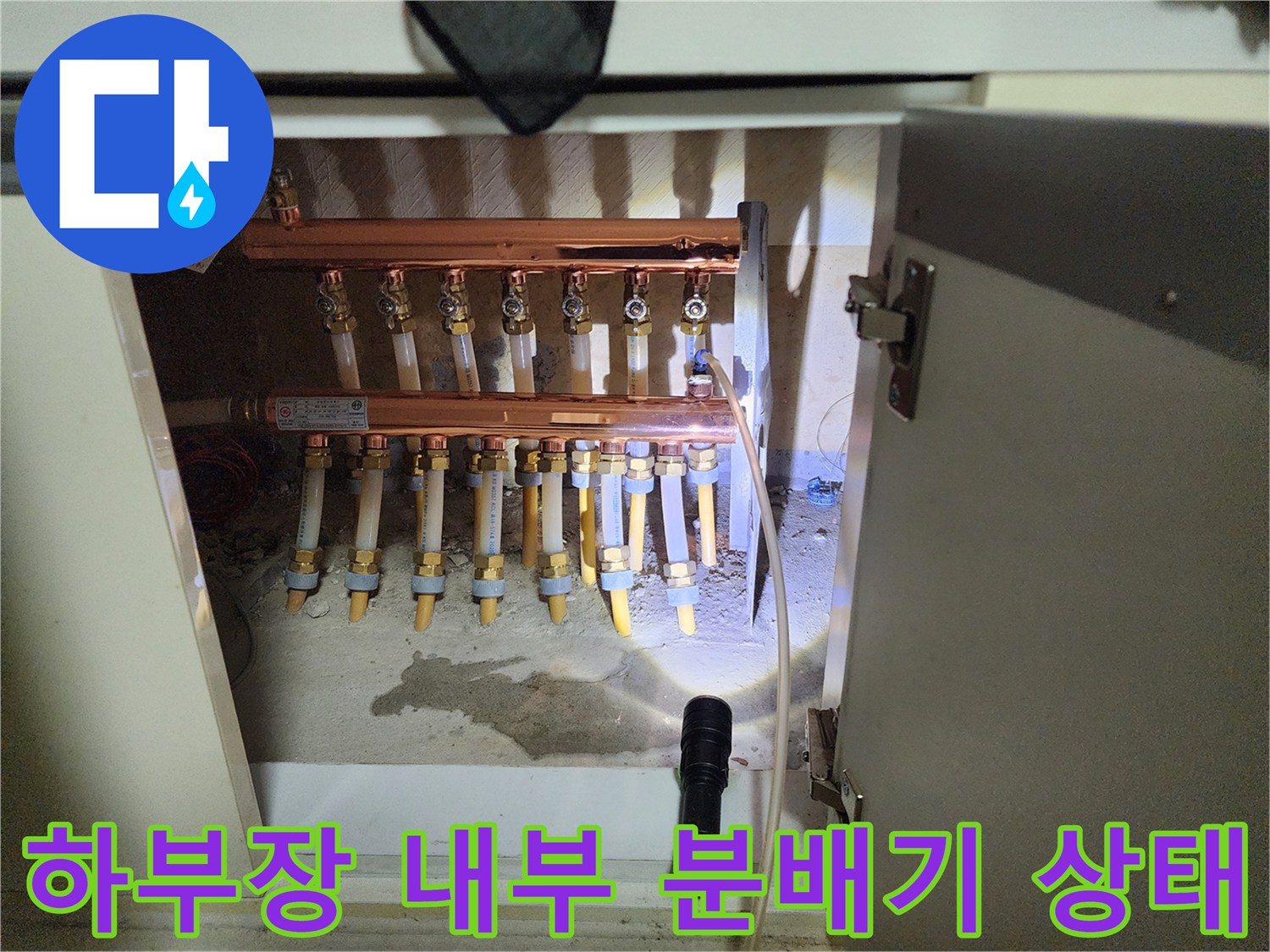 싱크대 아래 설치된 구리색 분배기와 다수의 배관 연결 부위
