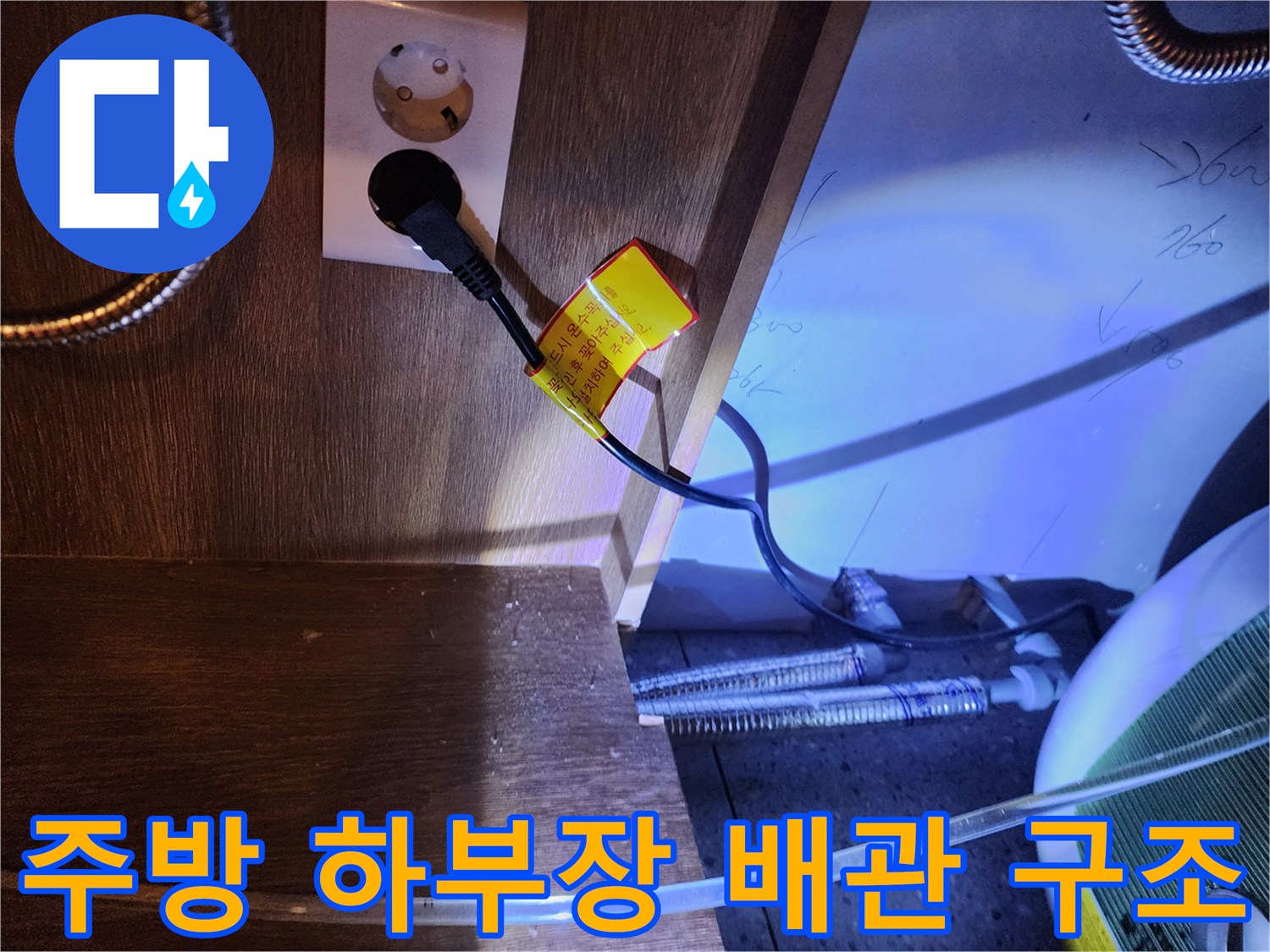 싱크대 밑 전기 온수기 전원선과 금속 호스의 연결 모습-누수 진단 중