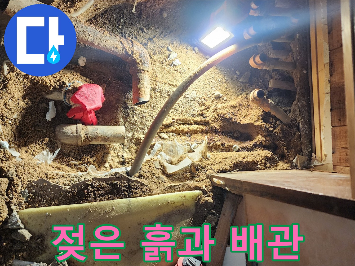 누수가 진행 중인 현장-물에 젖은 흙과 노후된 분배기 배관