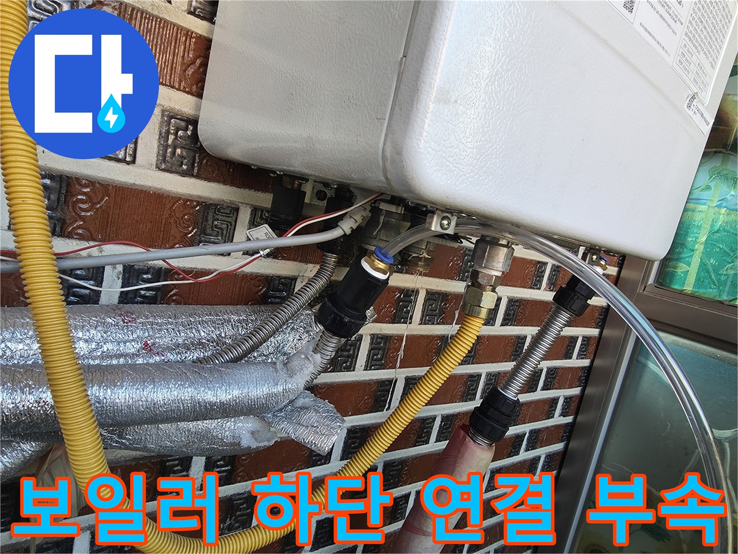 보일러 아래쪽에 위치한 노란색 보온재 배관과 금속 커플링 상세