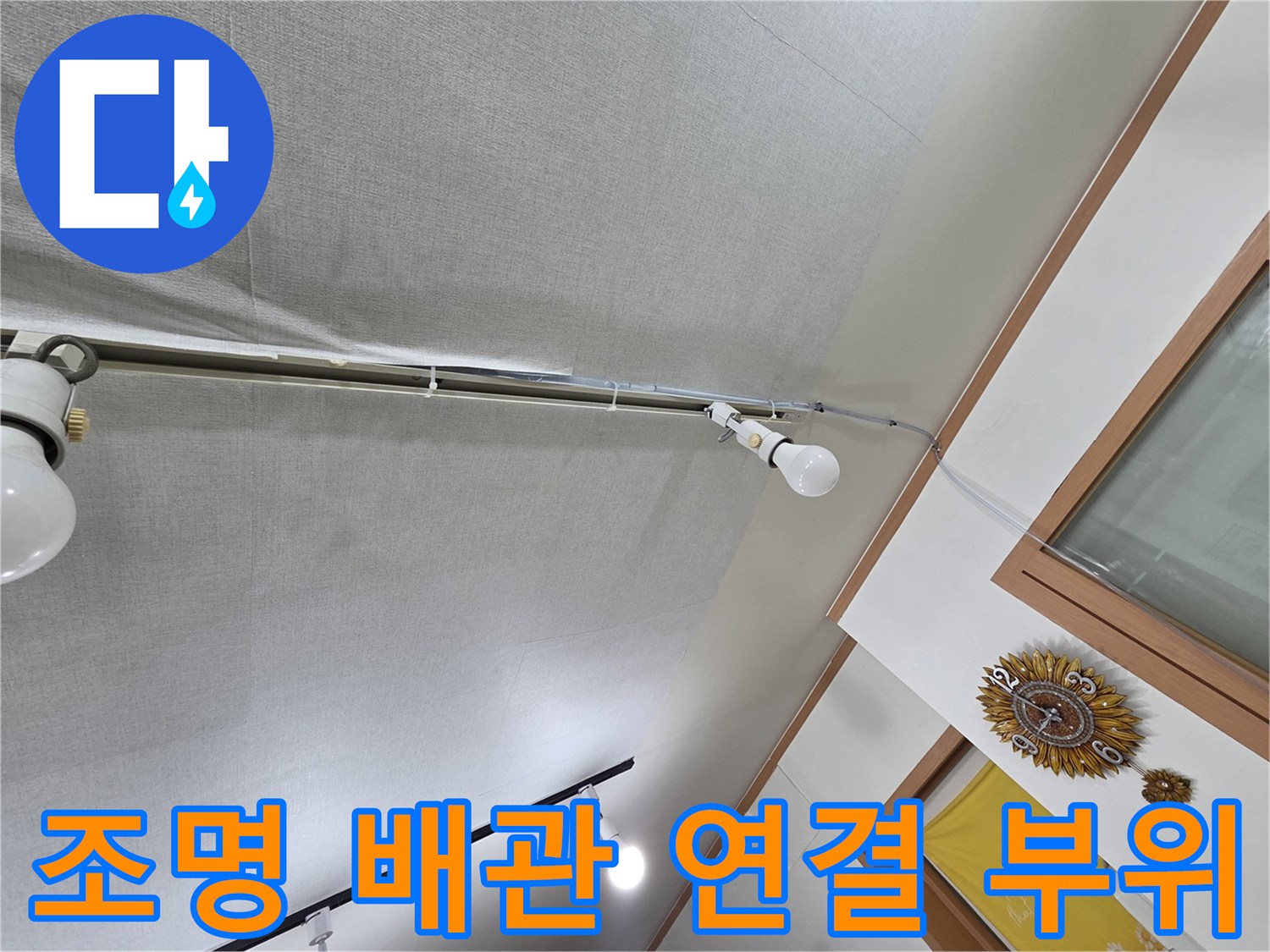 천장 전등 근처의 노출된 배관과 조명을 보여주는 이미지입니다.