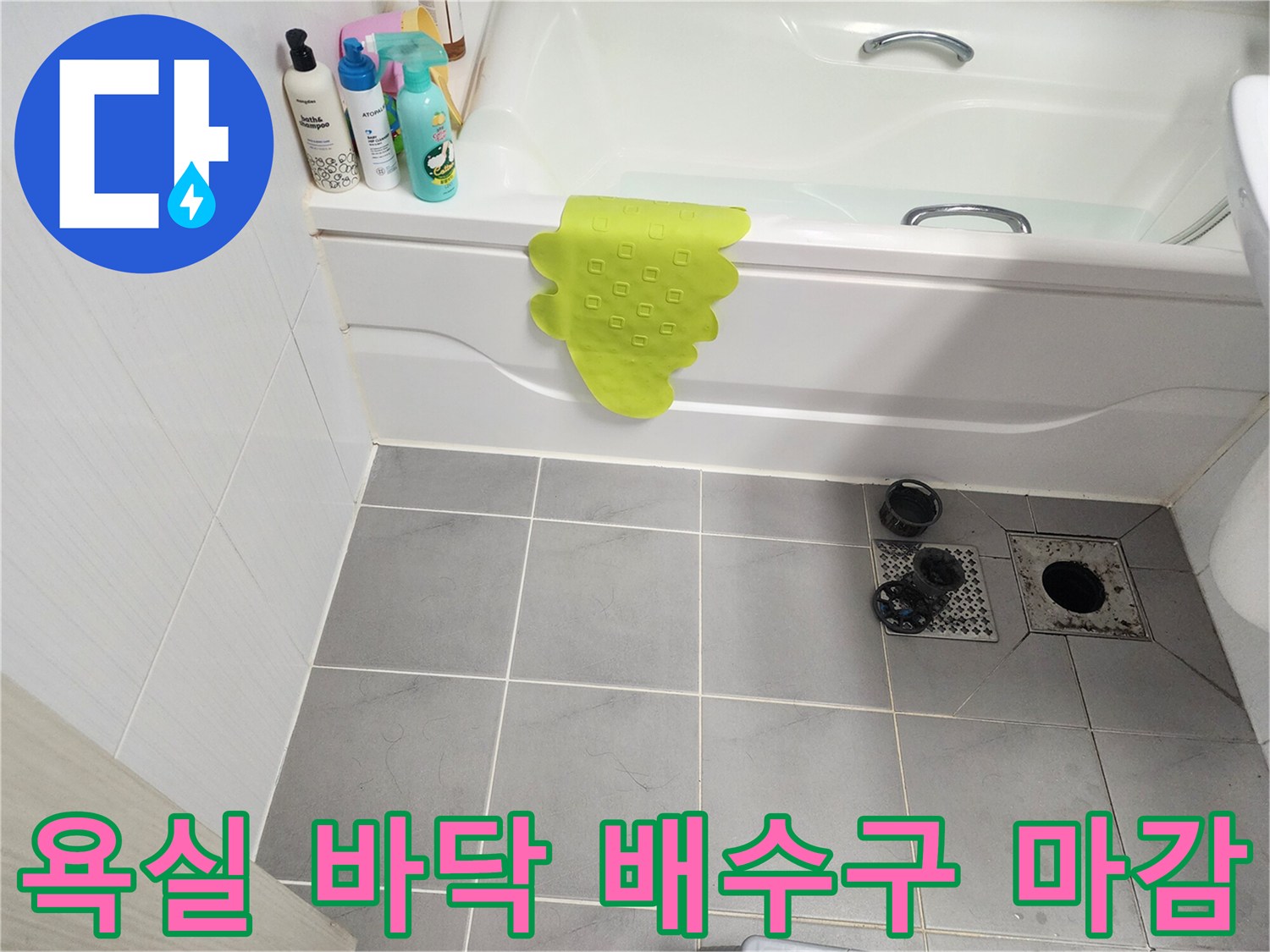 욕실 배수구 유가와 인접한 회색 타일의 모습