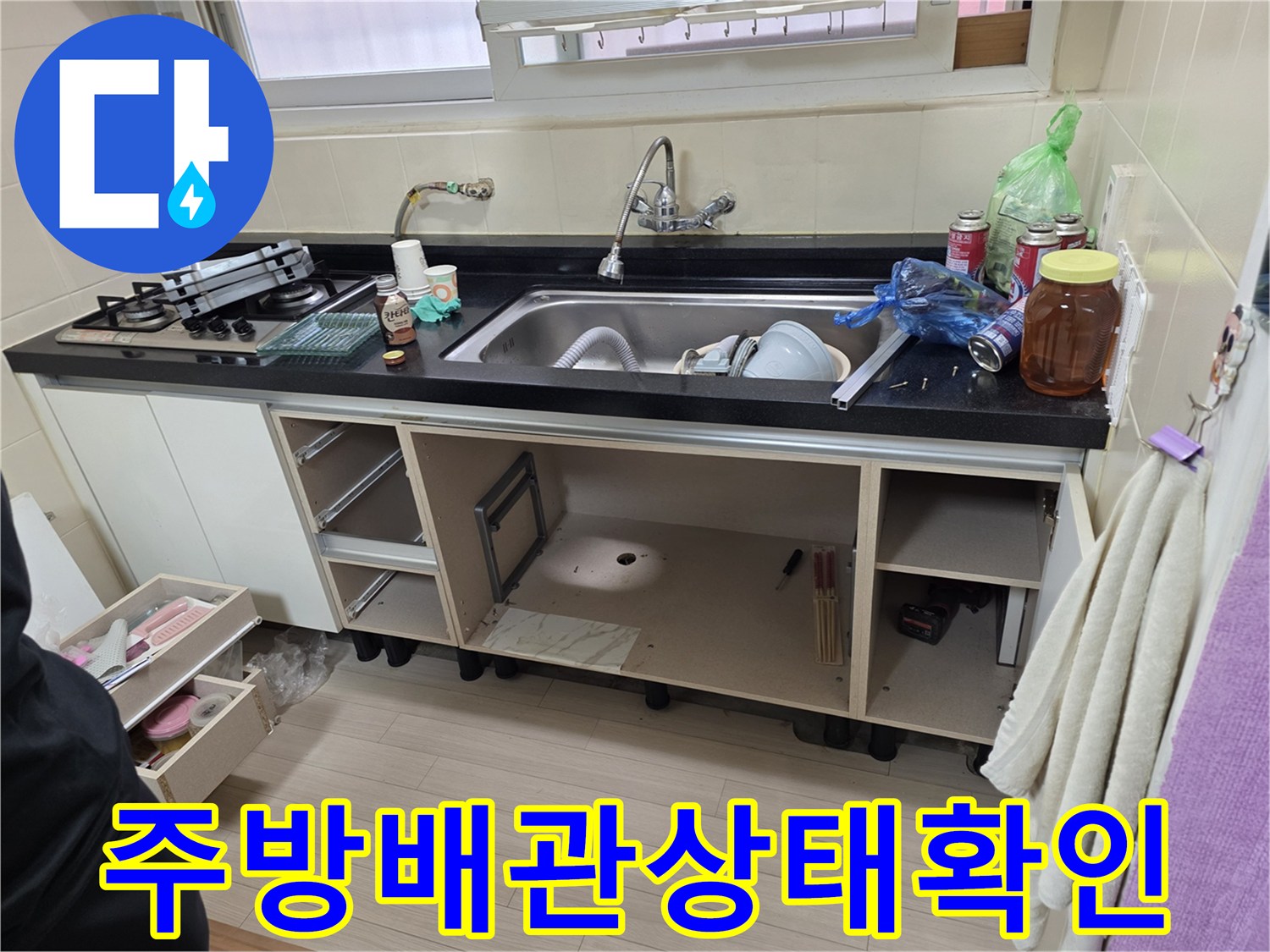 싱크대 아래쪽 공간을 확보하여 배관의 이상 여부를 정밀하게 조사하고 있습니다.