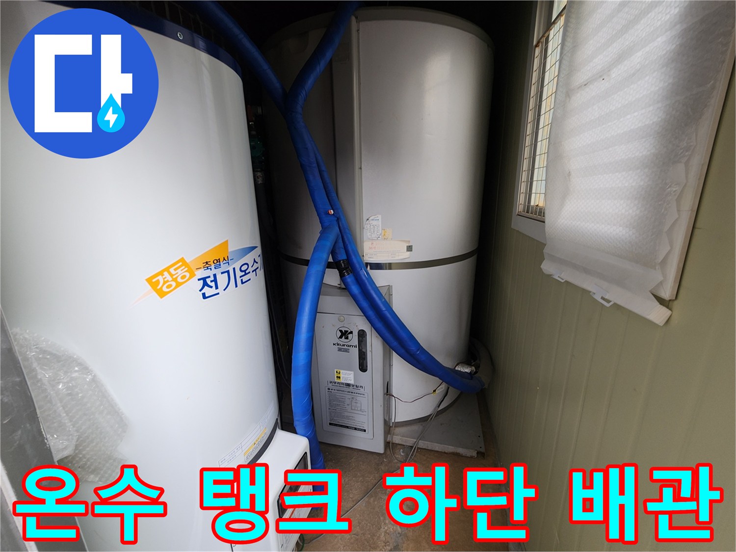 파란색 보온재로 감싸진 배측 배관이 흰색 온수 탱크에 연결되어 있습니다.