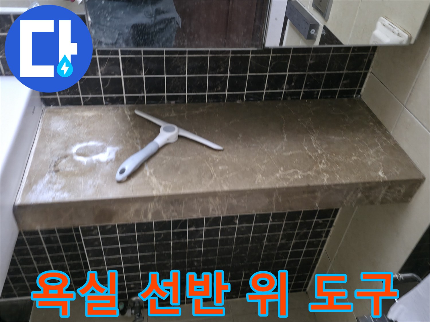 욕실 선반 위에 놓인 배관 점검용 수동 도구