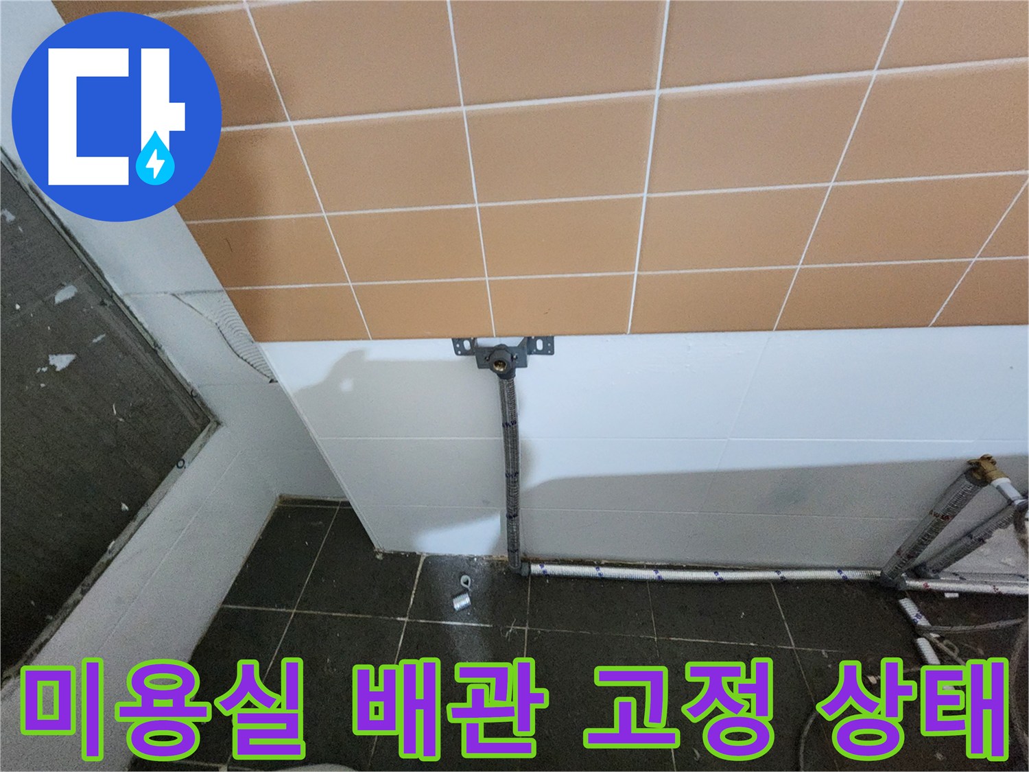 미용실 벽면 하단에 설치된 배관과 고정 브라켓의 모습입니다.
