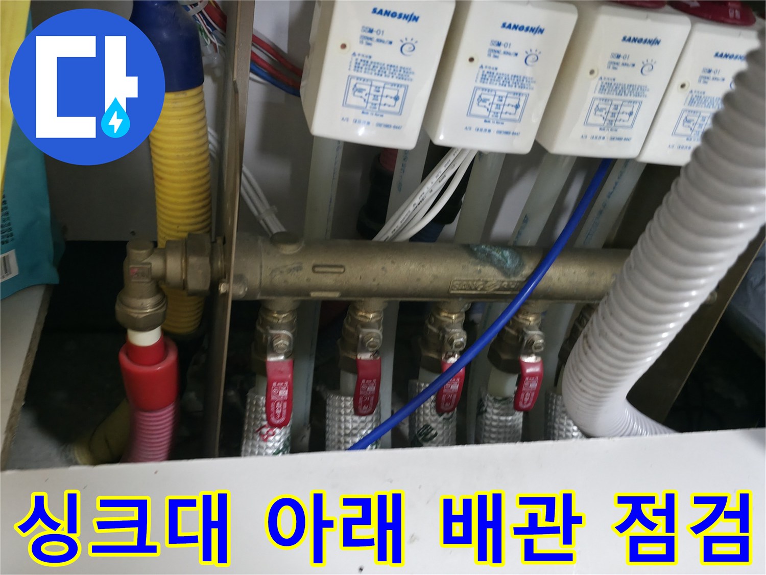 분배기 밸브와 가스 탐지 호스가 보이는 싱크대 하부 모습