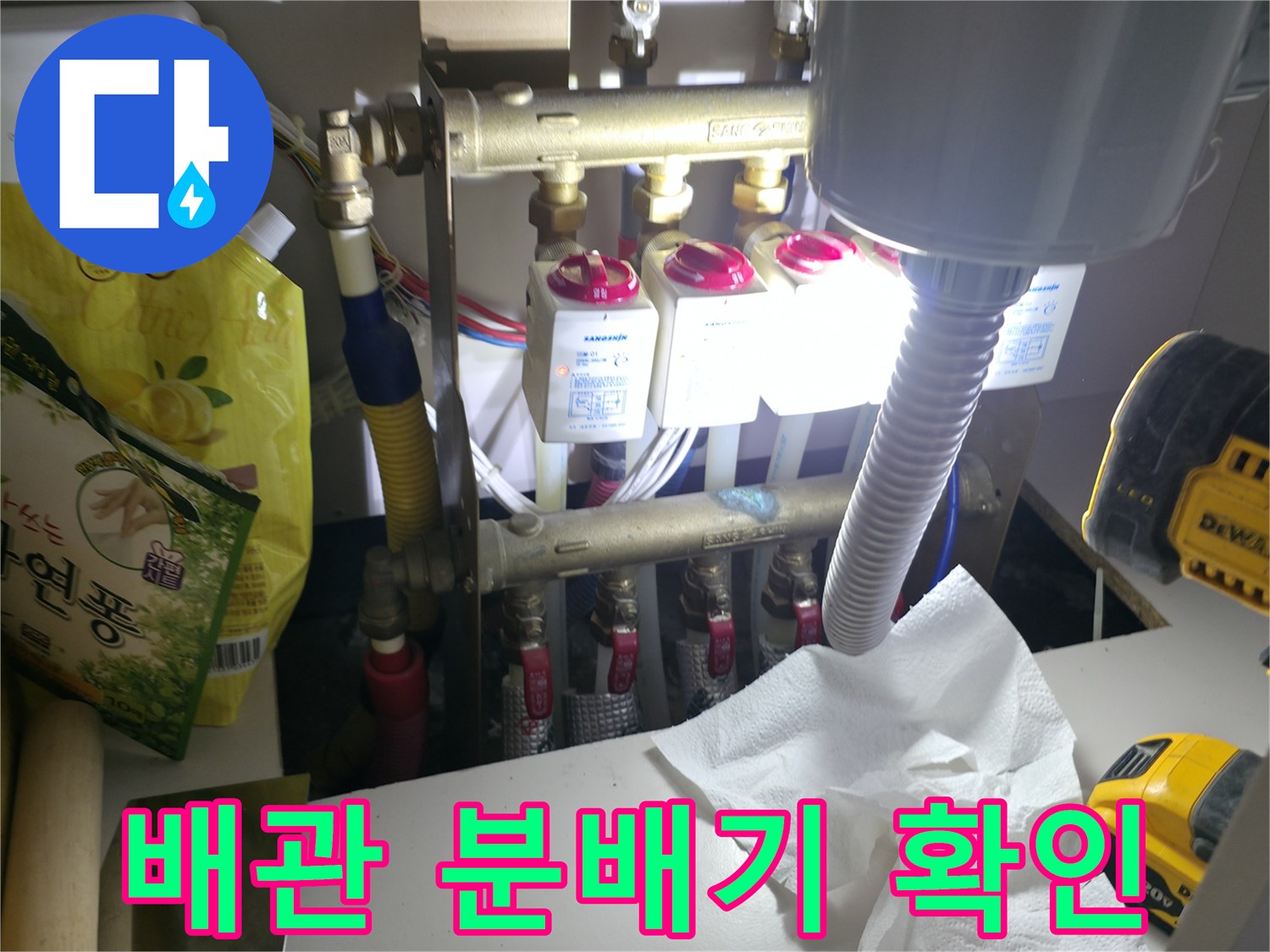 싱크대 아래 분배기 밸브와 탐지 장비가 있는 모습