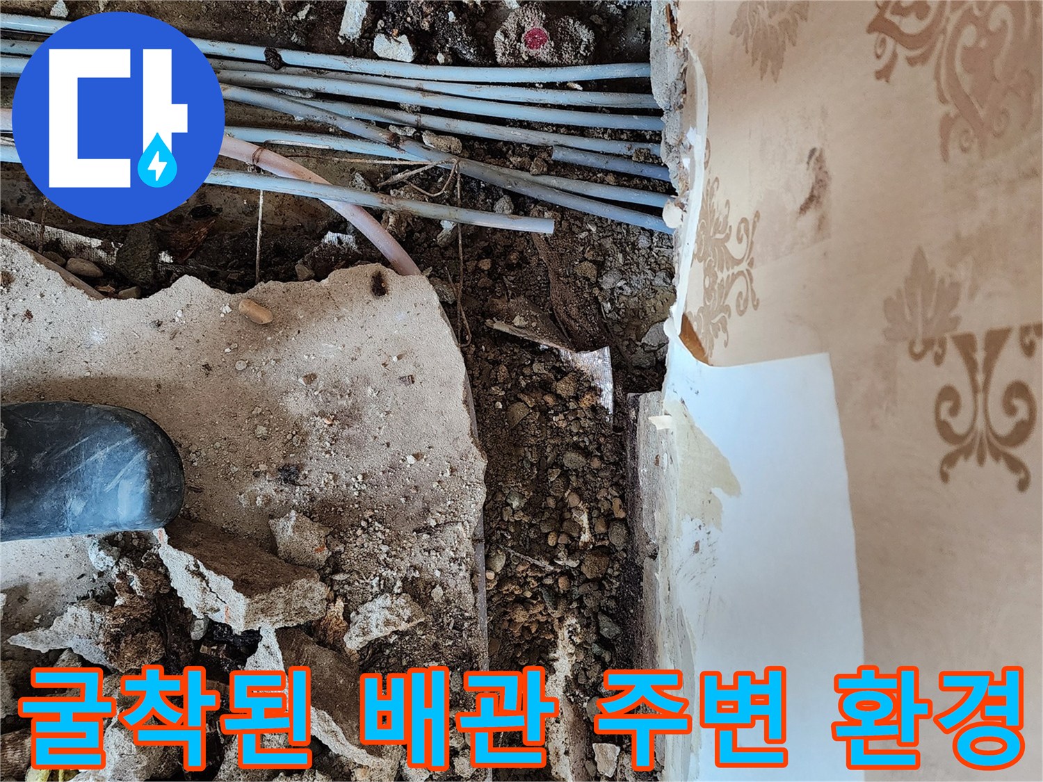 보산동 현장의 벽면 하부 굴착 부위로 노출된 매립 배선과 수도 배관의 모습입니다.