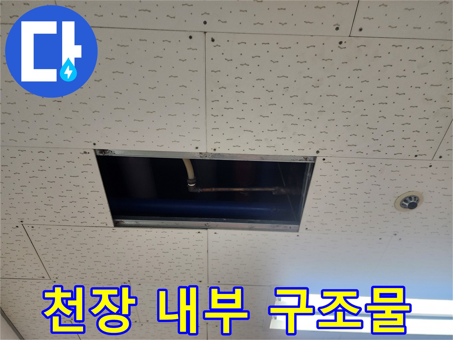 천장 점검구 안쪽의 배관과 구조물을 촬영한 사진입니다.