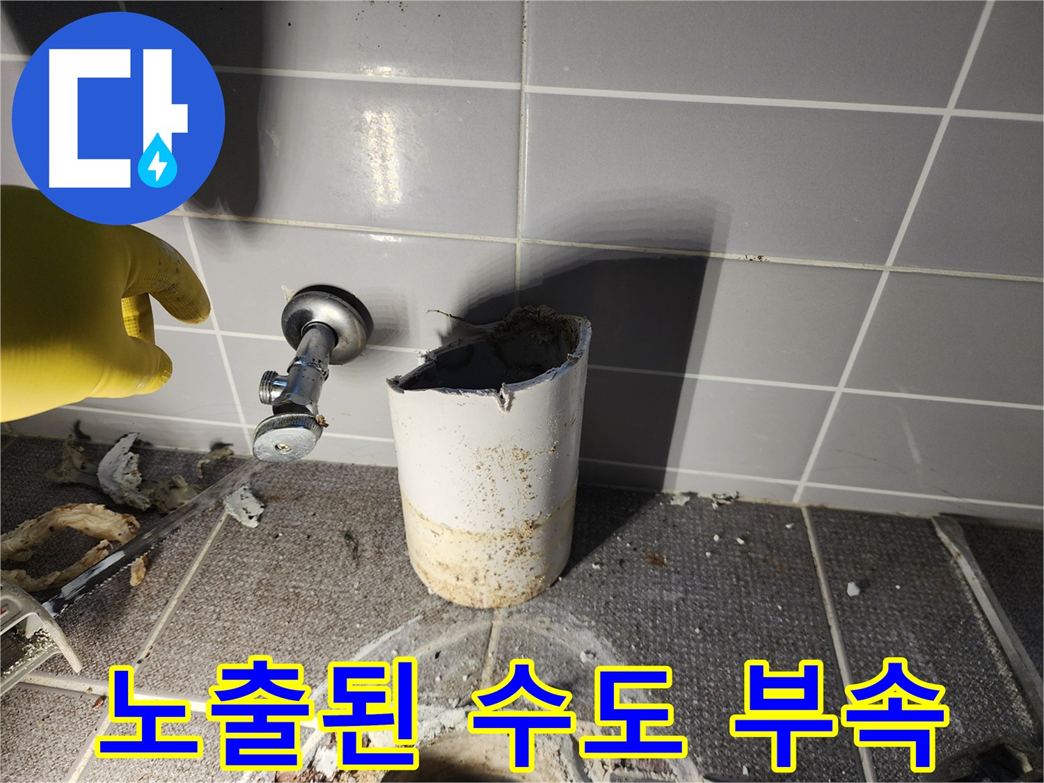 파손된 타일 뒤로 드러난 수도 밸브와 배관 연결 부위