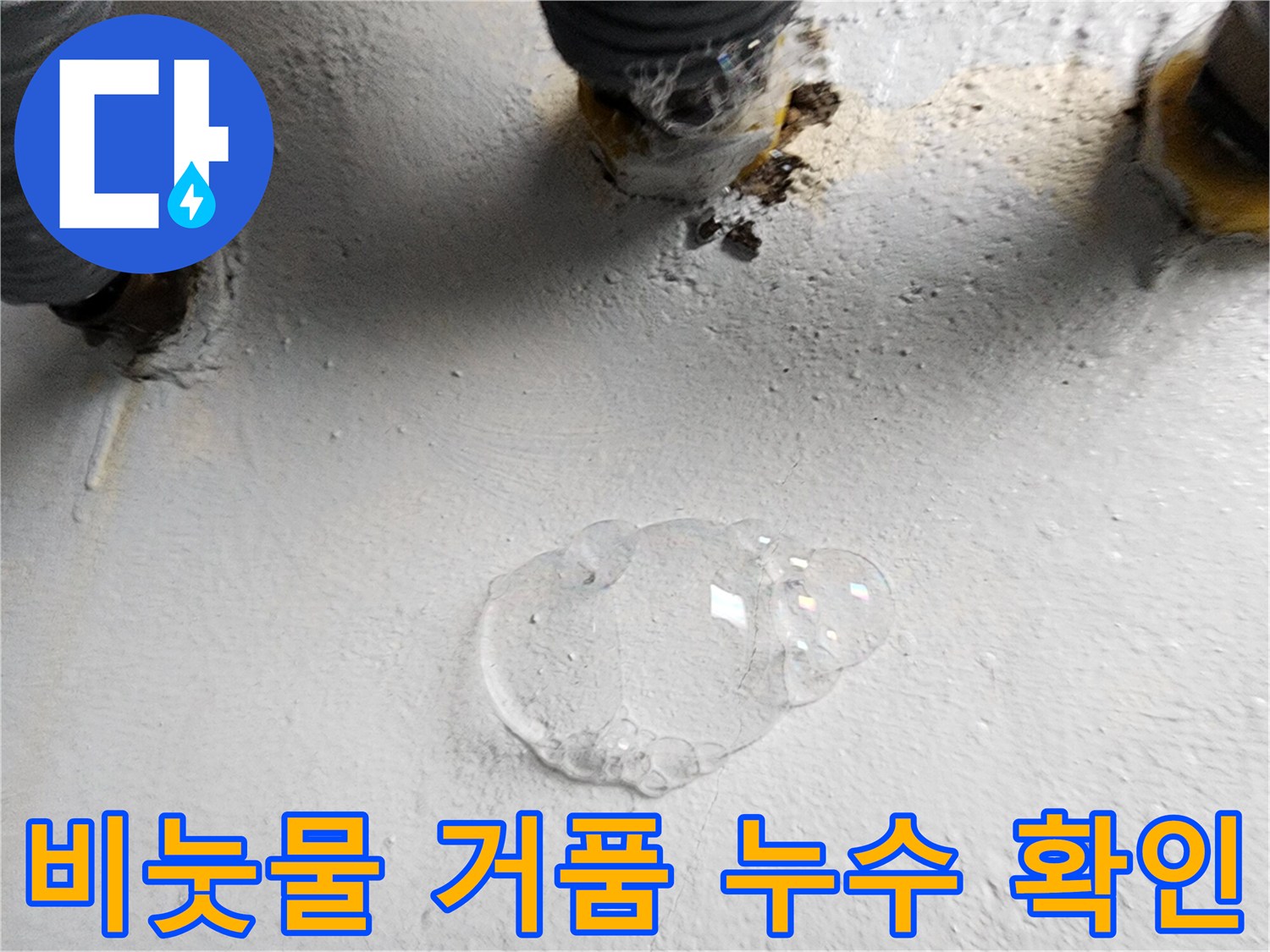하수구 배관 틈새에서 비눗물이 부풀어 오르며 누수를 나타내고 있습니다.