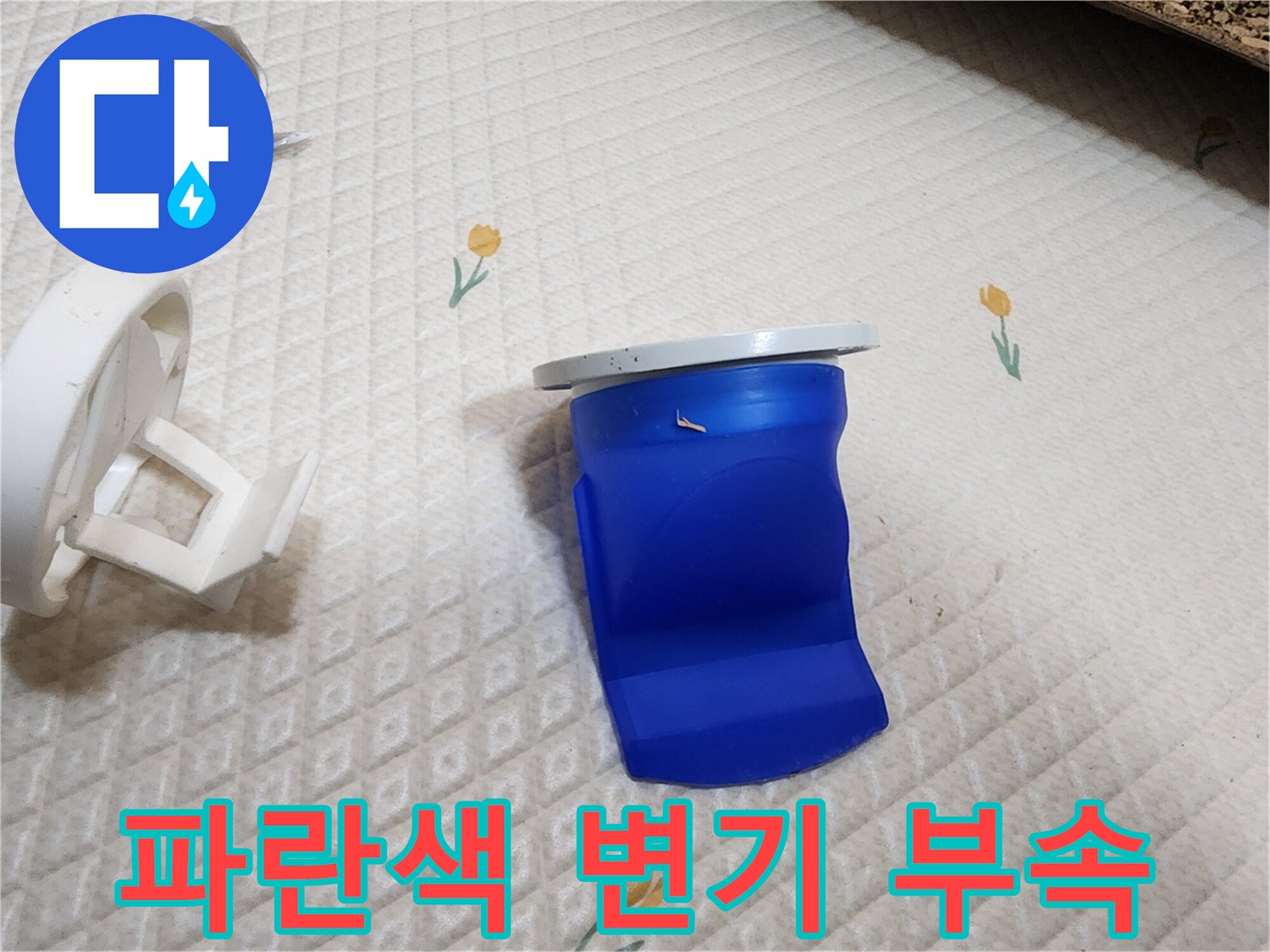 변기 탈거 후 노출된 파란색 배관 커넥터와 흰색 플라스틱 부품