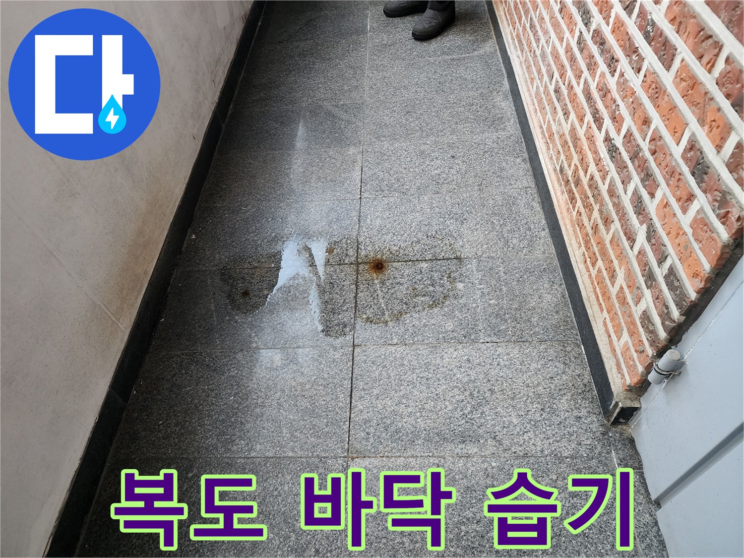 물기가 스며들어 어둡게 변한 복도 타일 표면 상태