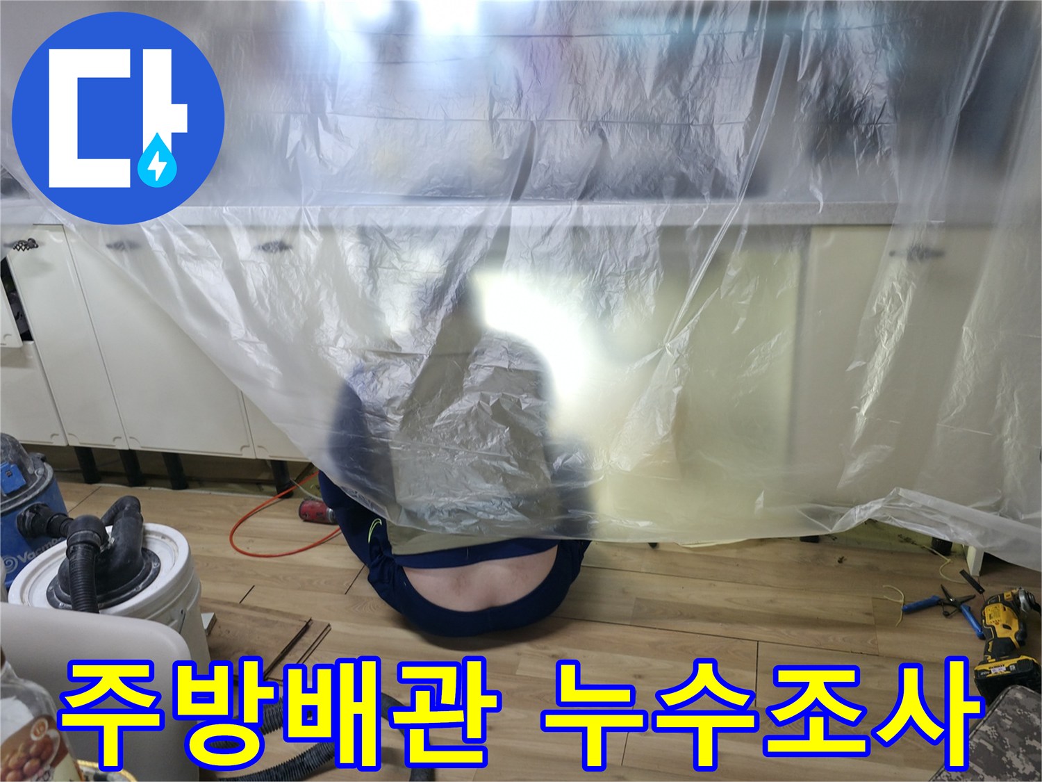 누수 탐지를 위해 싱크대 하단부를 비닐로 덮어 작업 환경을 조성한 사진