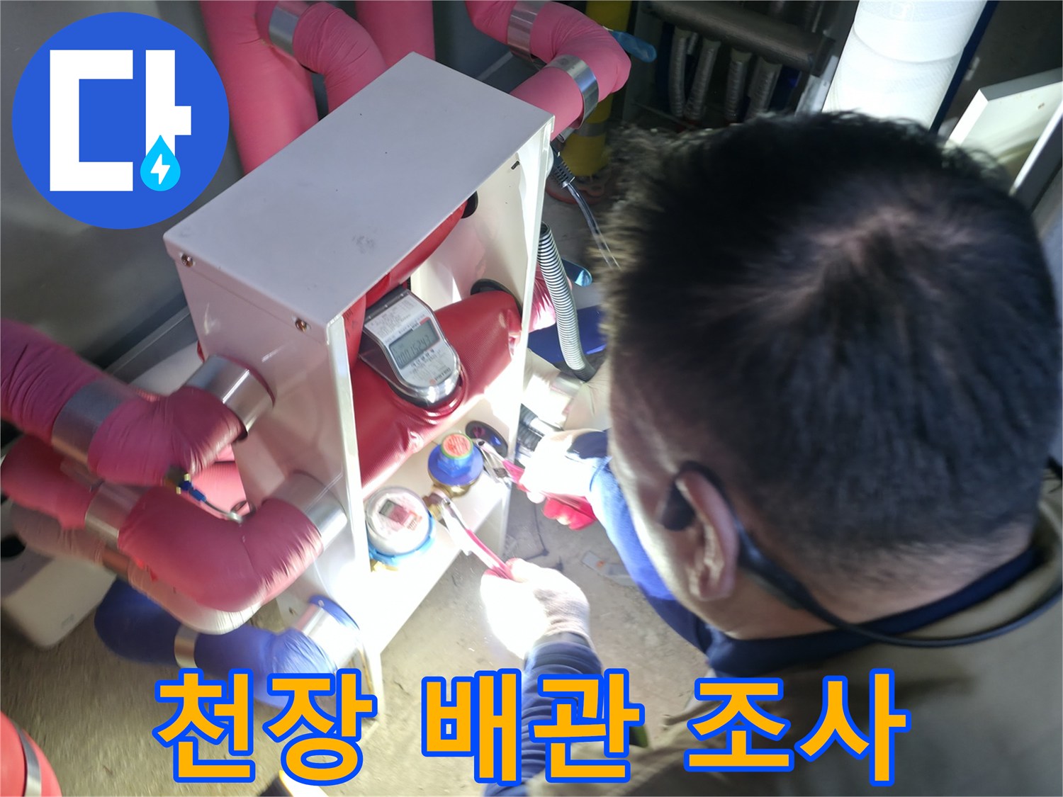 엔지니어가 분홍색 보온재가 씌워진 배관의 연결부를 면밀히 살핍니다.