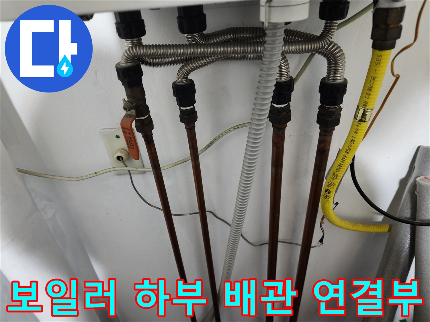 보일러-하부에-연결된-동배관과-노란색-슬리브의-주름관-전경