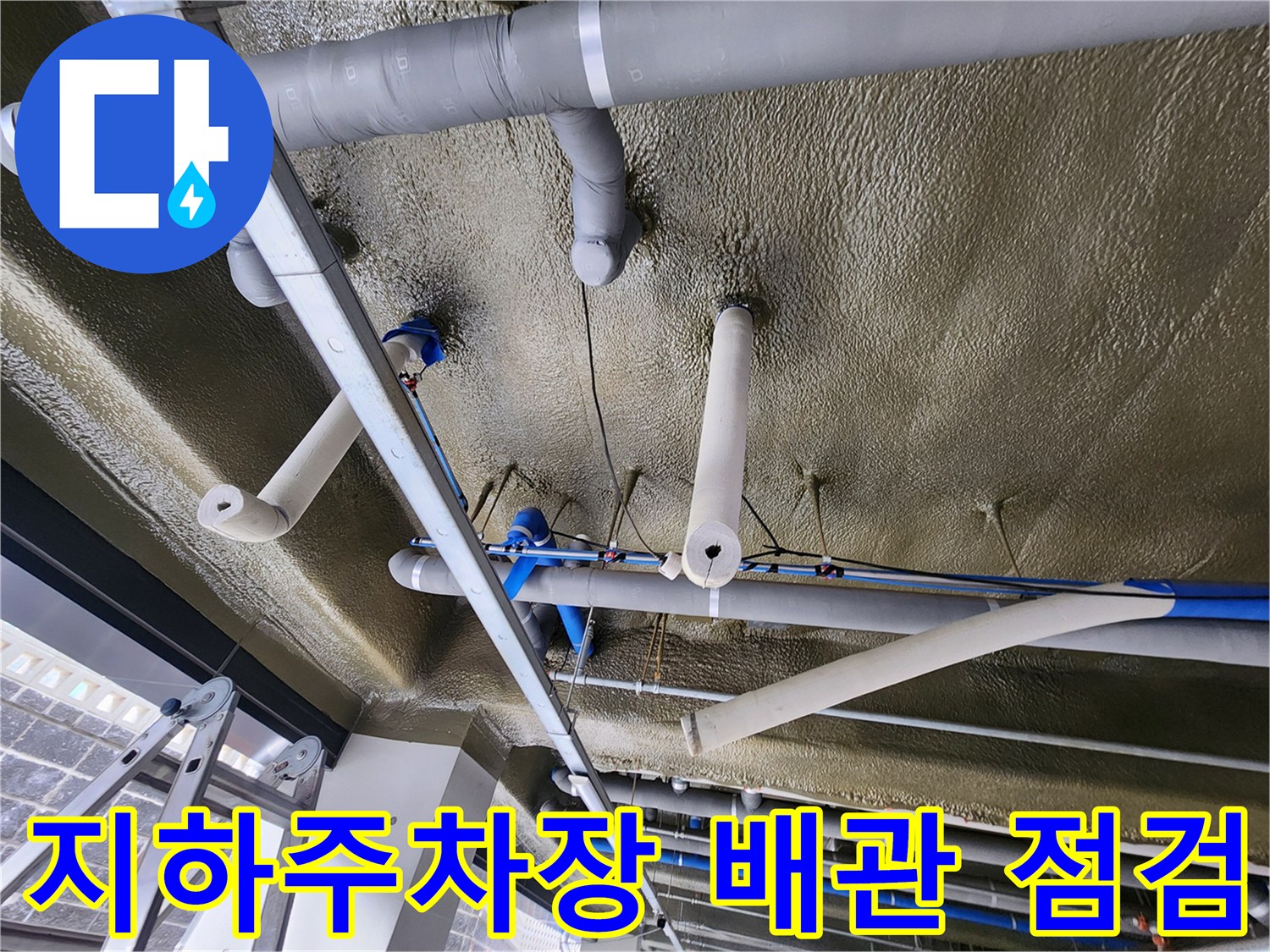 지하주차장 천장에 설치된 보온재 마감된 배관 모습