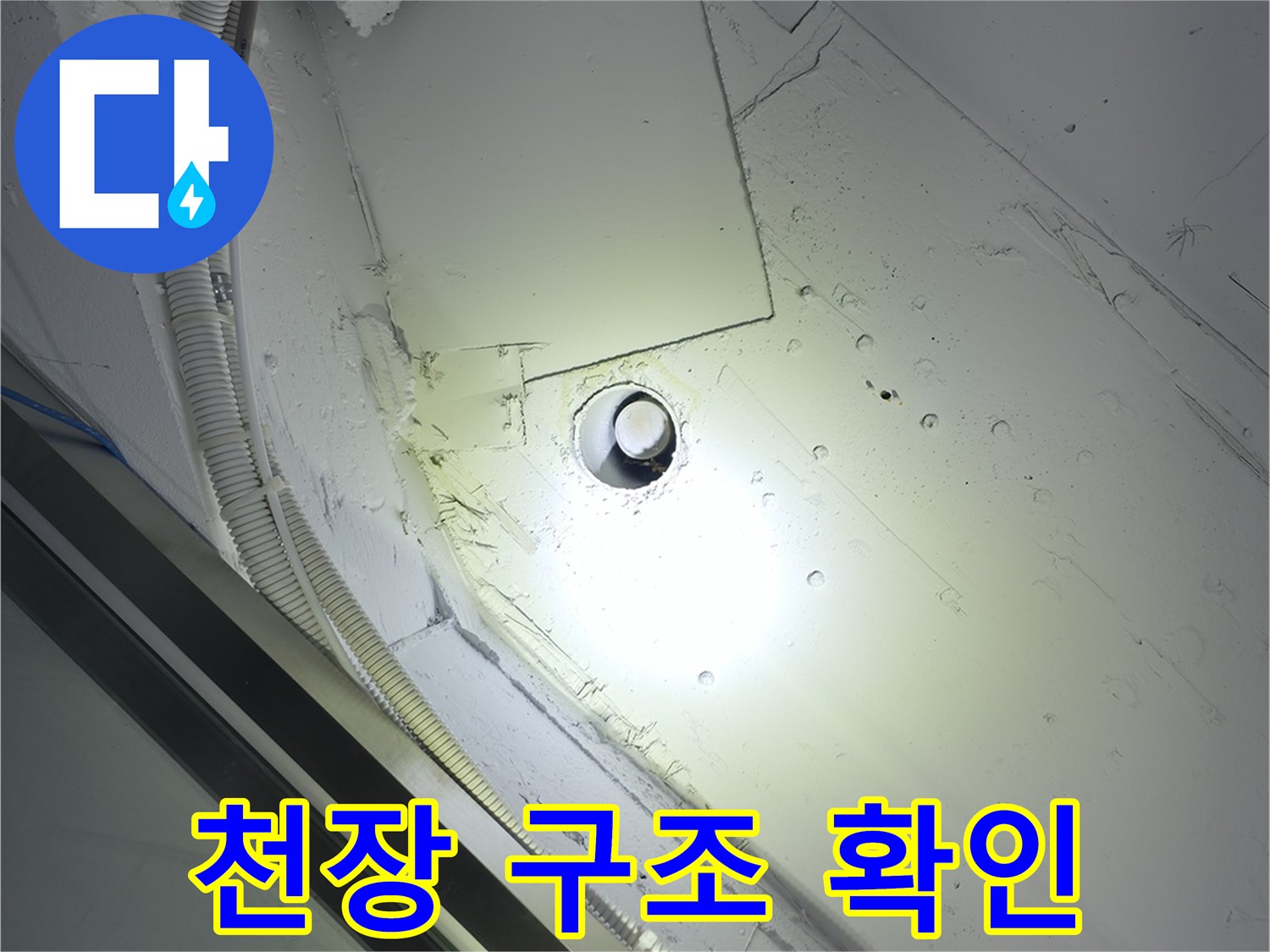 천장 마감재와 노출된 배관 및 전선 보호관 모습