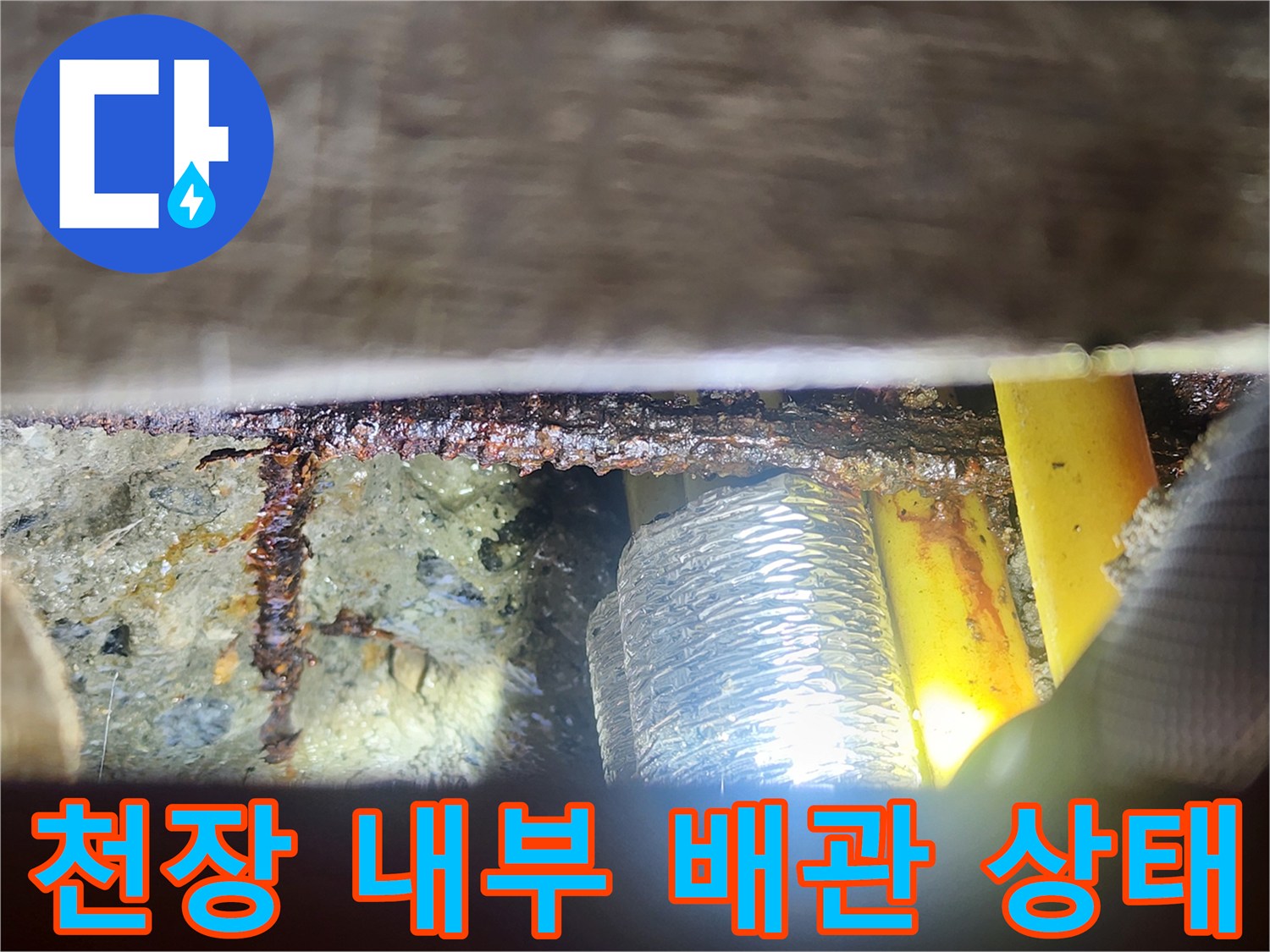 천장 내부에 노출된 노란색 배관과 은박 보온재의 모습