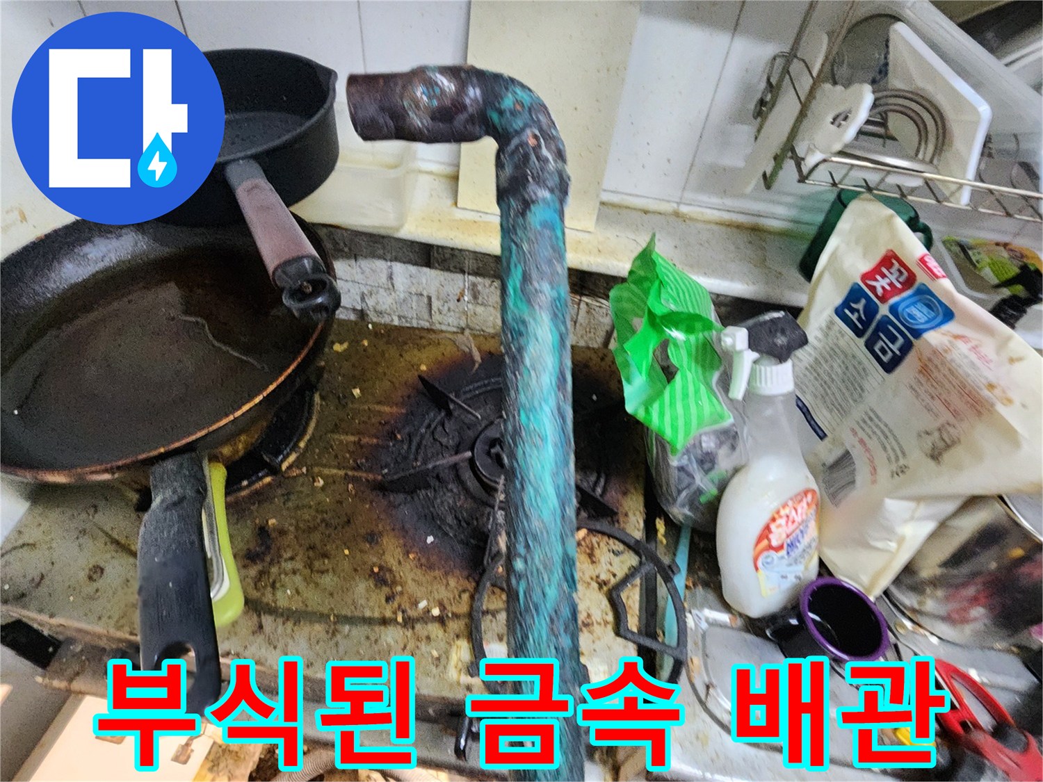 싱크대 하단에 위치한 부식되고 초록색 녹이 핀 금속 배관 모습