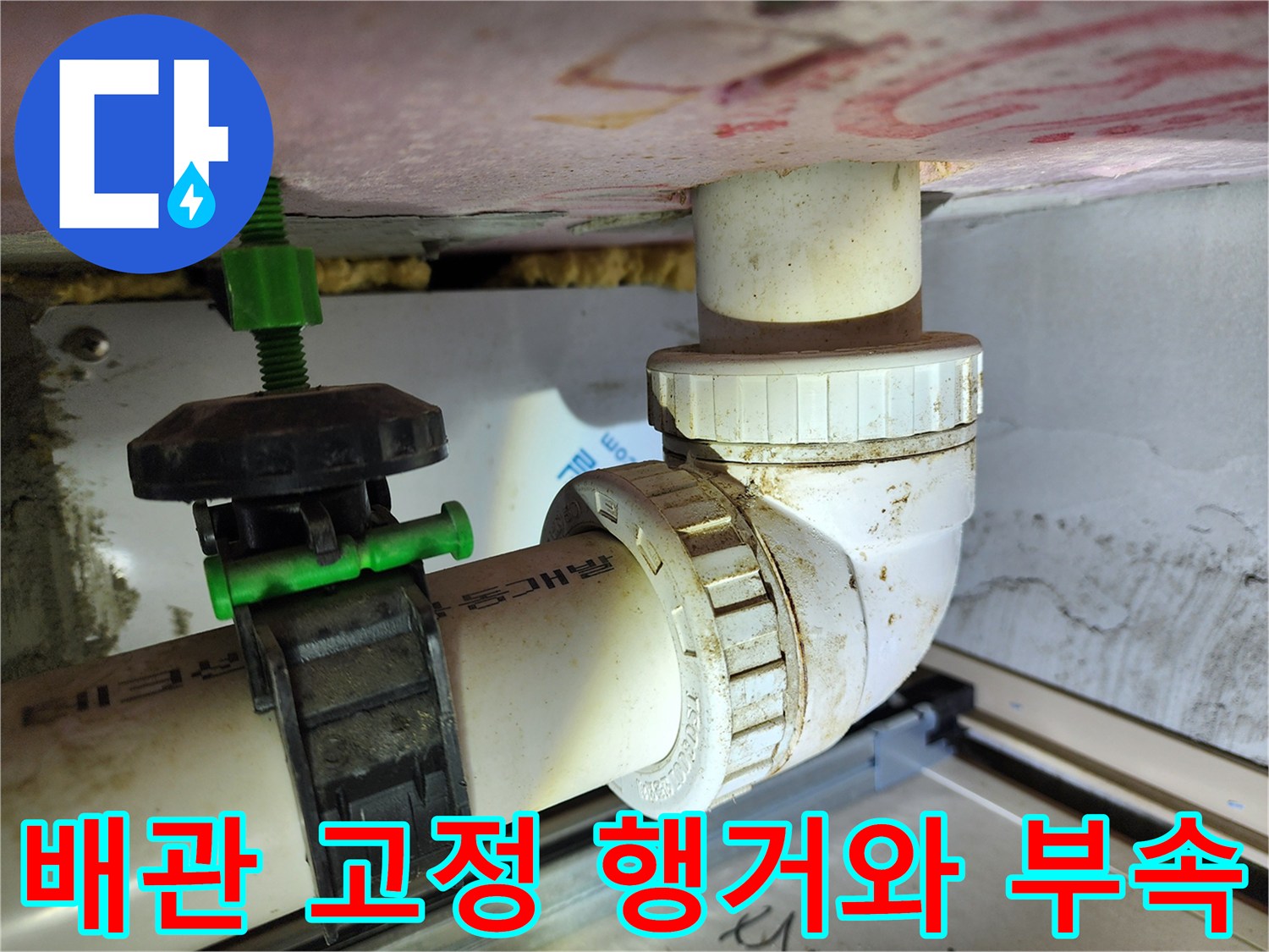 배관을 지지하는 녹색 행거와 연결된 백색 배관의 모습입니다.