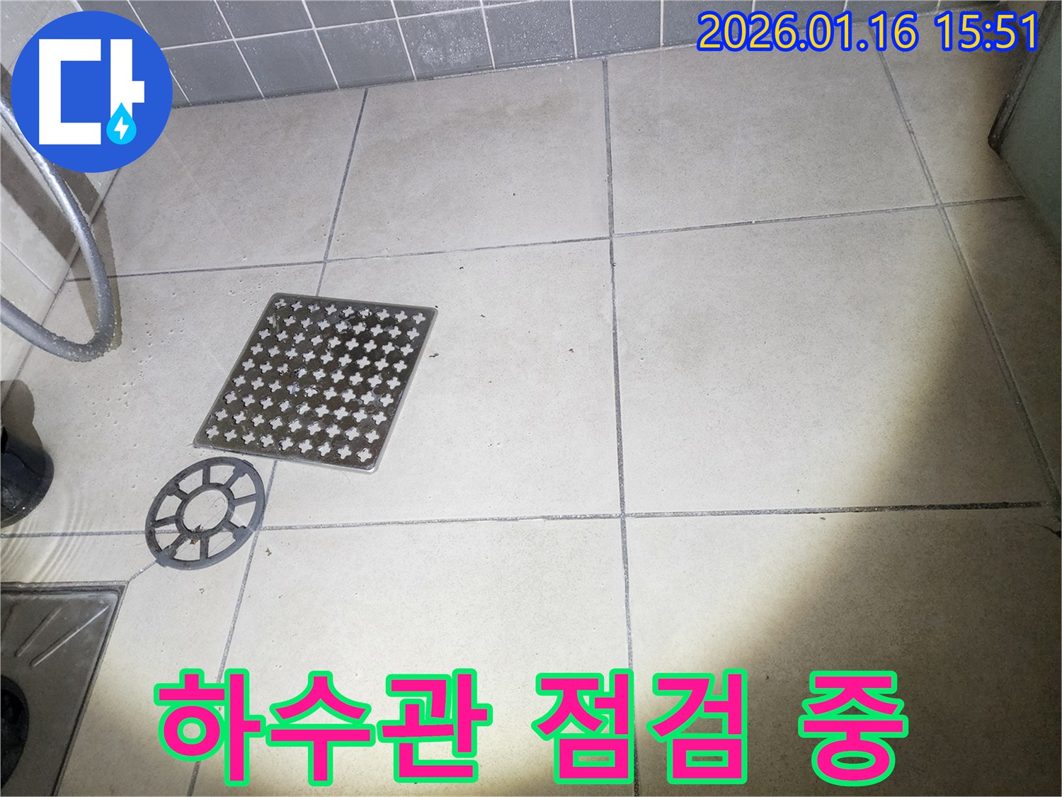 이 이미지는-욕실 배수구의-덮개를 열고-하수관 연결 부위를-점검하는-과정을 담고 있습니다