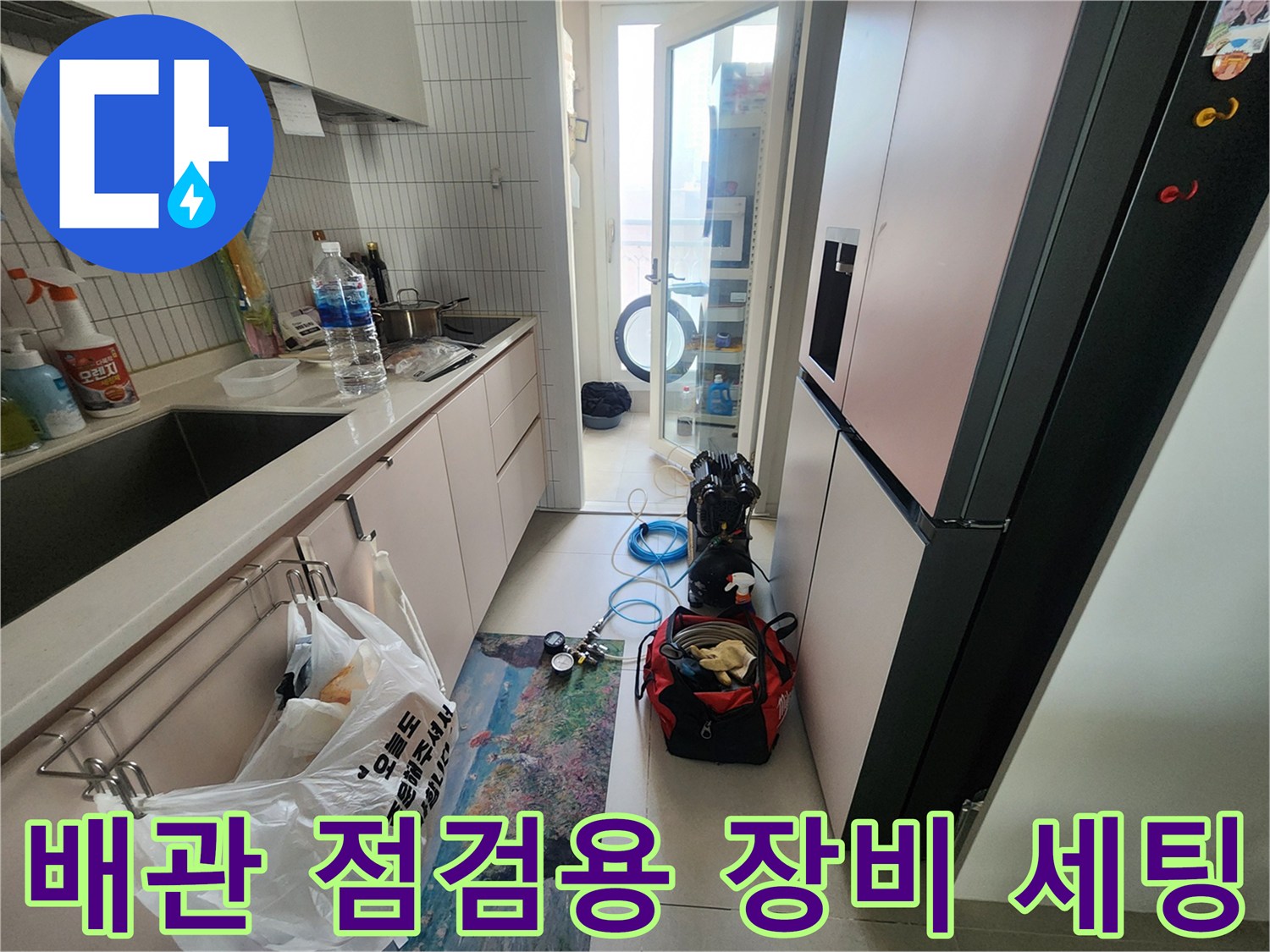 주방과 다용도실 경계 바닥에 놓인 누수 탐지용 압력계와 공구함