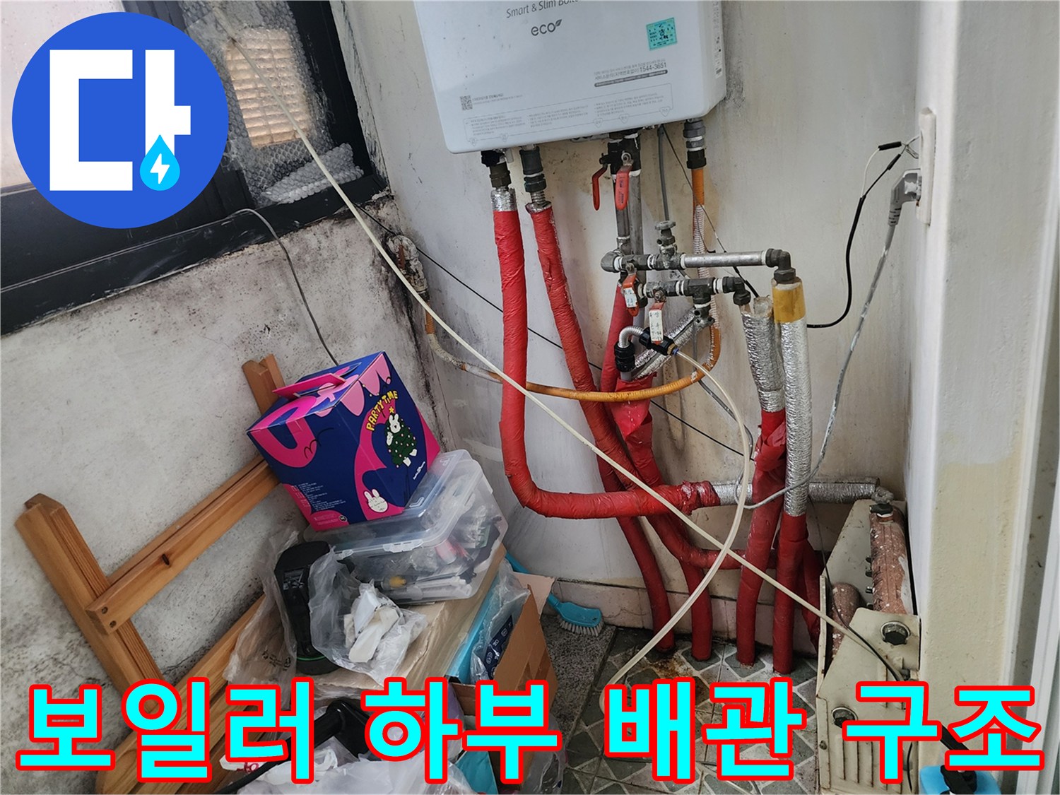 보일러실의 붉은색 배관과 연결 부속들의 근접 사진