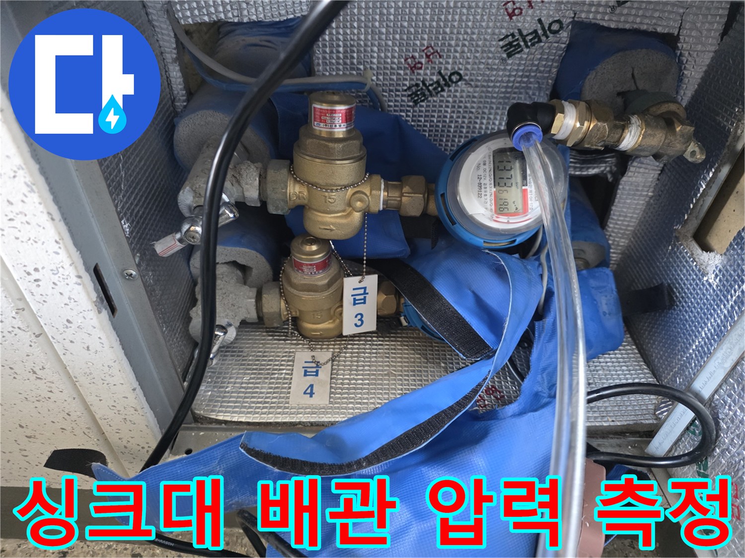 싱크대 하부 배관에 연결된 디지털 압력계와 계량기 모습