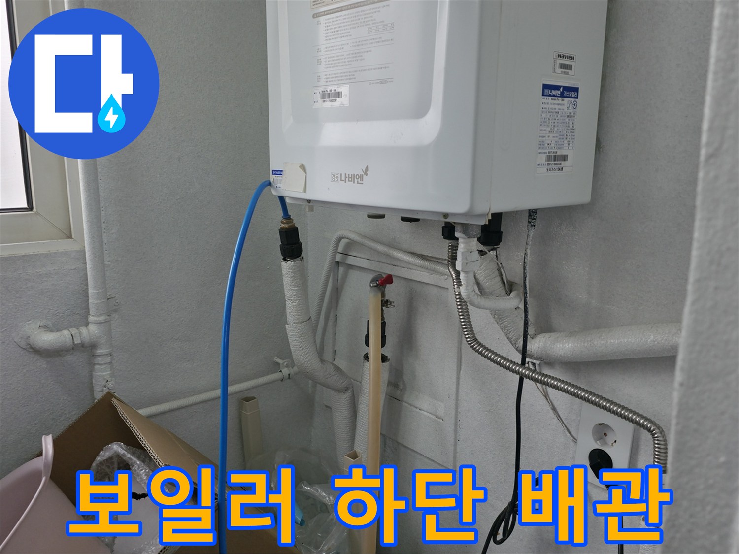 보일러 아래쪽으로 연결된 파란색 호스와 흰색 배관들