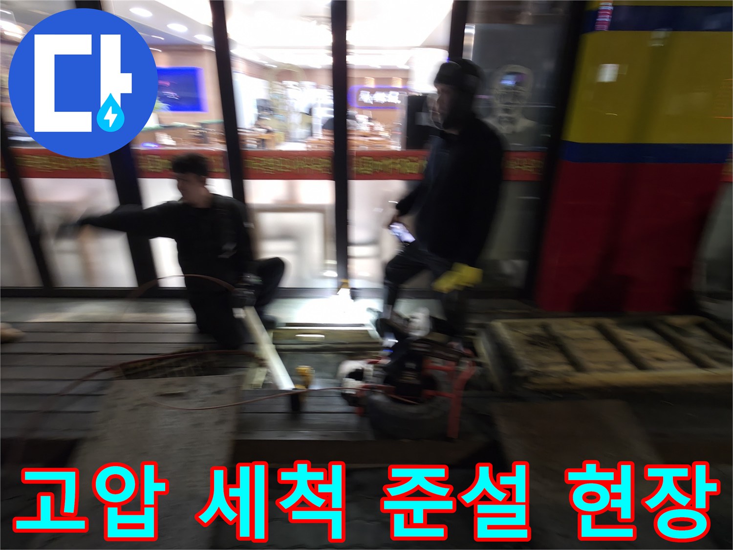 전문 기술자가 고압 세척 장비를 사용하여 배관 속 이물질을 제거하는 모습