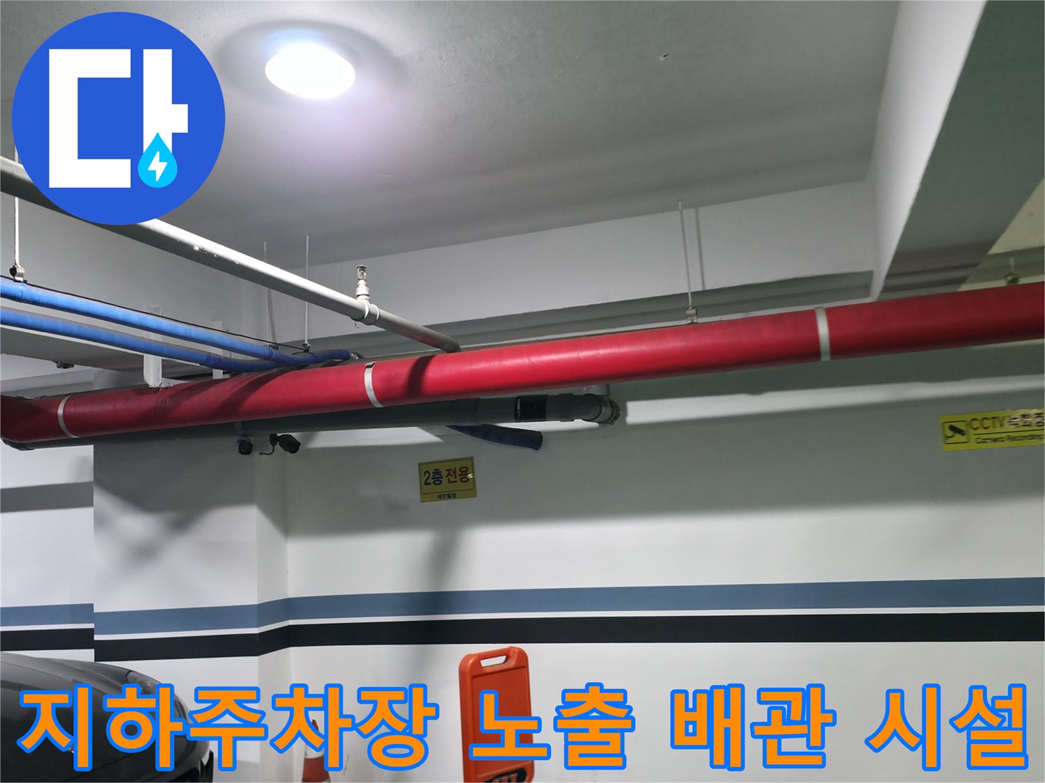 지하 주차 공간 내 설치된 붉은색과 파란색의 노출형 상하수도 배관 시스템