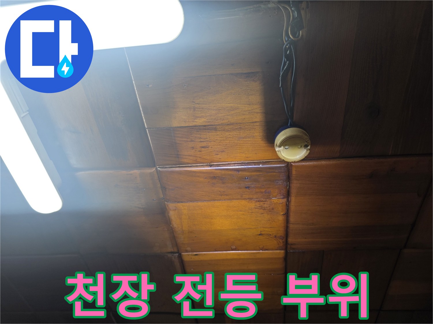 천장 전등 배선이 연결된 콘센트 형태의 부품과 나무 천장
