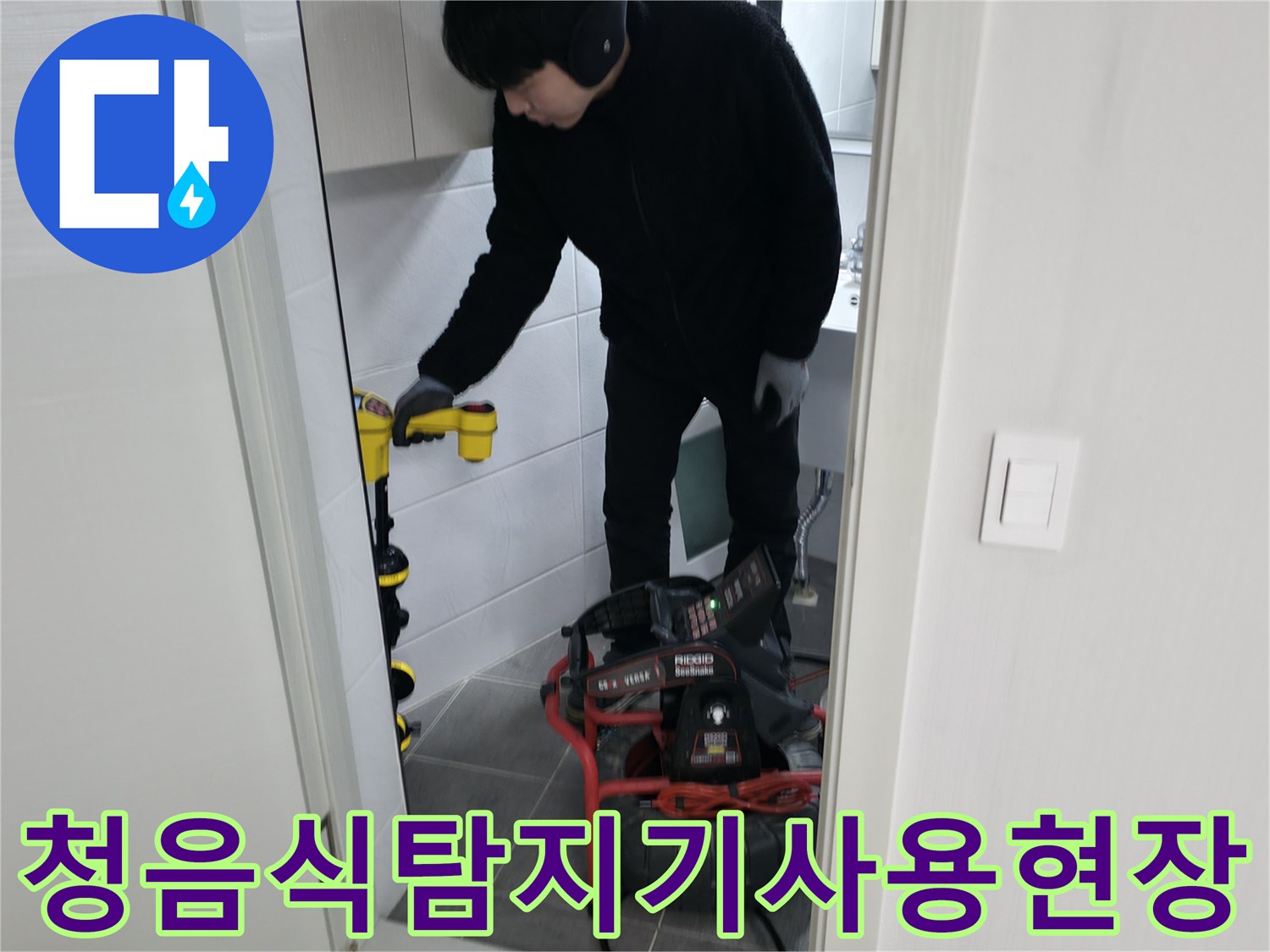 화장실바닥에서 청음식 탐지 장비를 사용하여 배관 위치를 파악하는 모습
