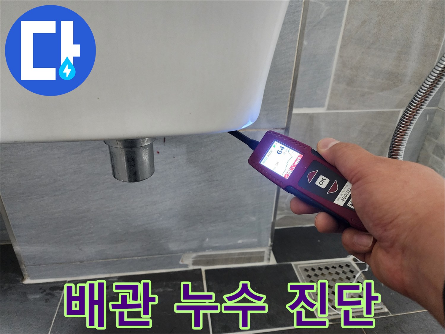 변기 하부 배관 부근의 누수 여부를 판단하기 위해 탐지기를 사용하는 모습입니다.