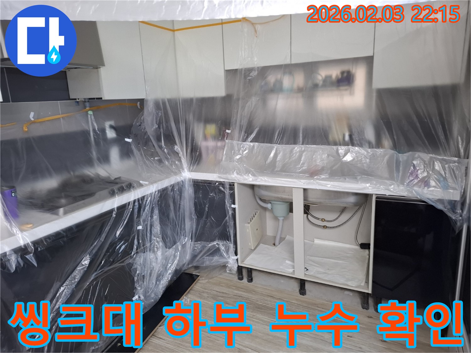 씽크대 하부 누수 확인 - 씽크대 하부에서 누수 지점을 찾기 위해 꼼꼼하게 살펴보고 있습니다 - 숙련된 기술로 문제 해결!