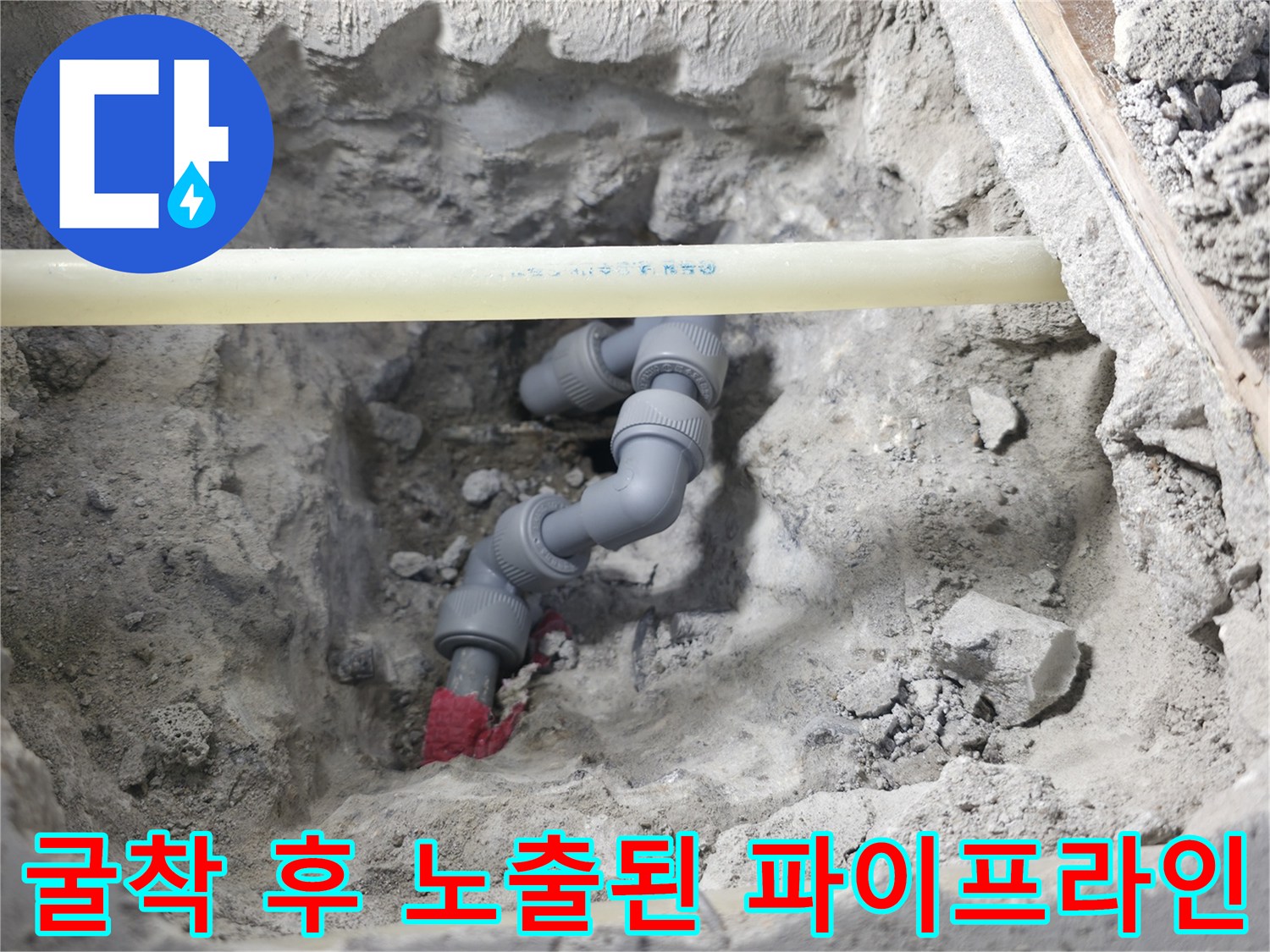 파내어진 구덩이 속 배관과 연결 부속의 근접 촬영