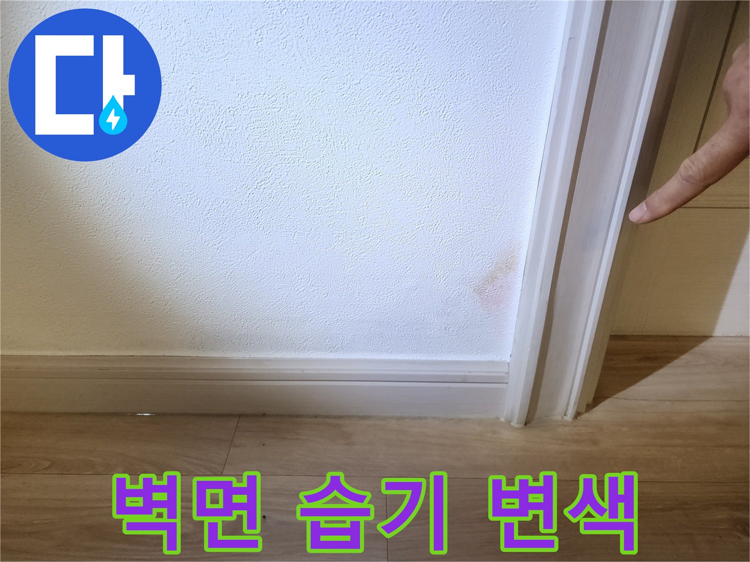 흰색 벽지에 나타난 분홍빛 습기 얼룩을 근접 촬영한 사진입니다.
