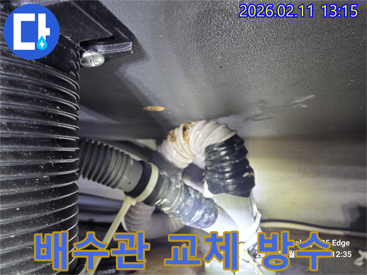 싱크대 배수관의 노후로 인해 누수가 발생하여-새로운 배관으로 교체하는 작업 현장을 담은 사진입니다